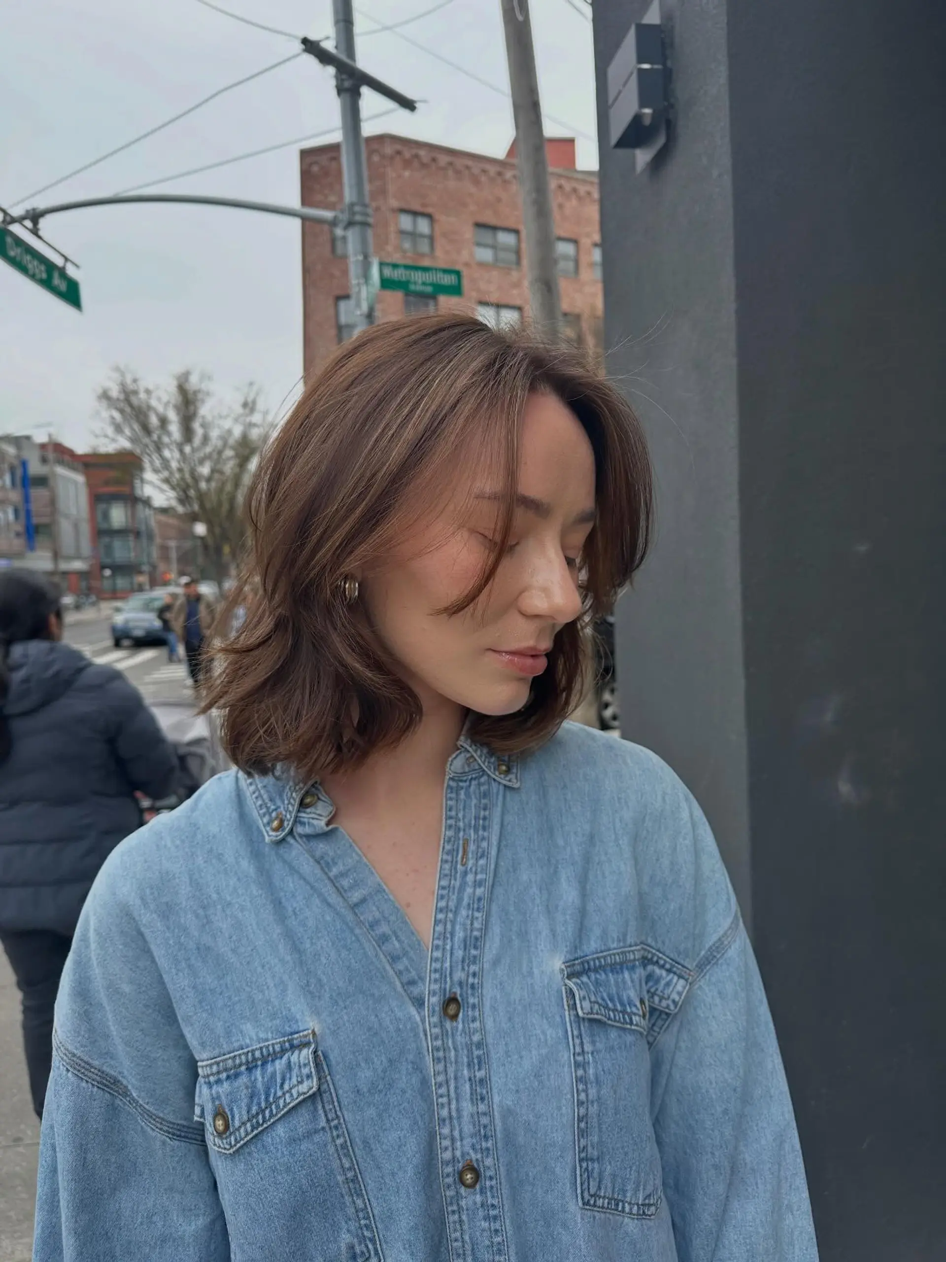 A textured, shoulder-length bob with soft face-framing curtain bangs and subtle warm brown dimension. 1