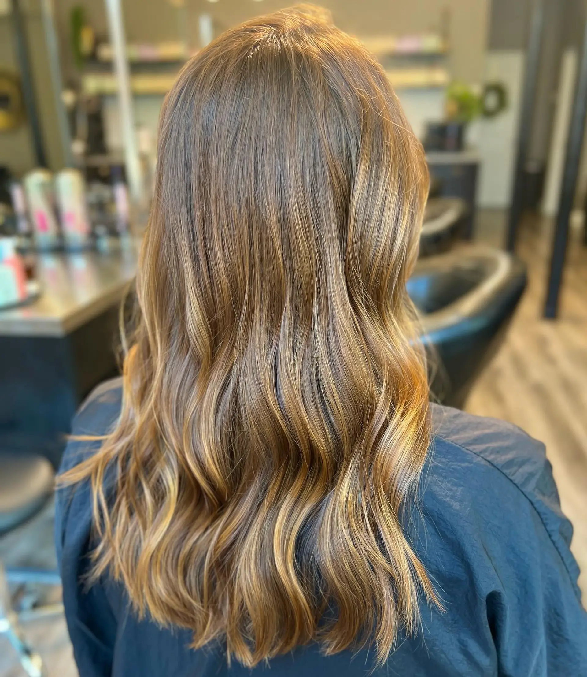 Long, wavy hair with a balayage effect, featuring blonde highlights blended into a brown base. 1
