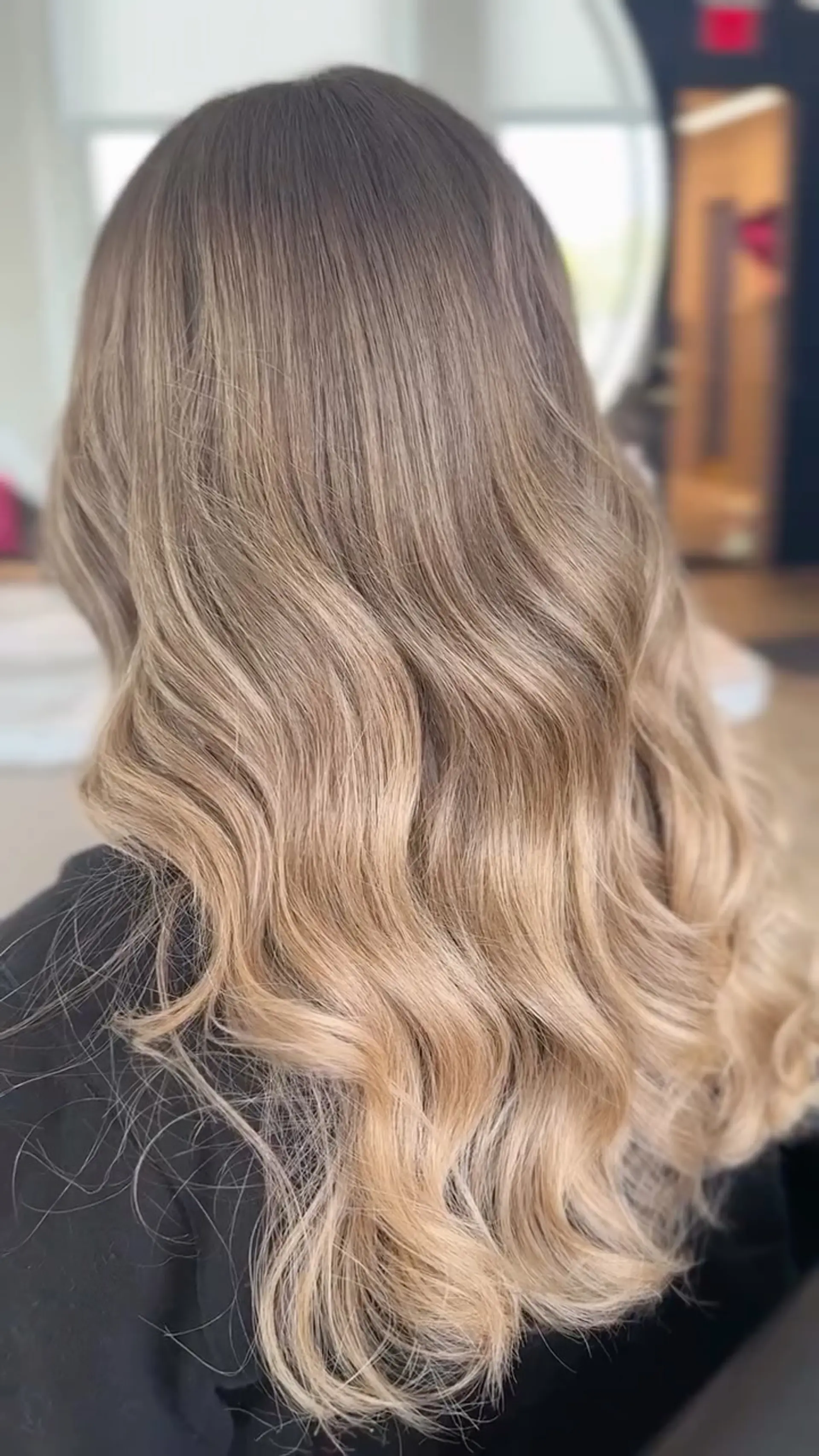 Long hair featuring a seamless blonde balayage styled in soft, cascading waves. 1