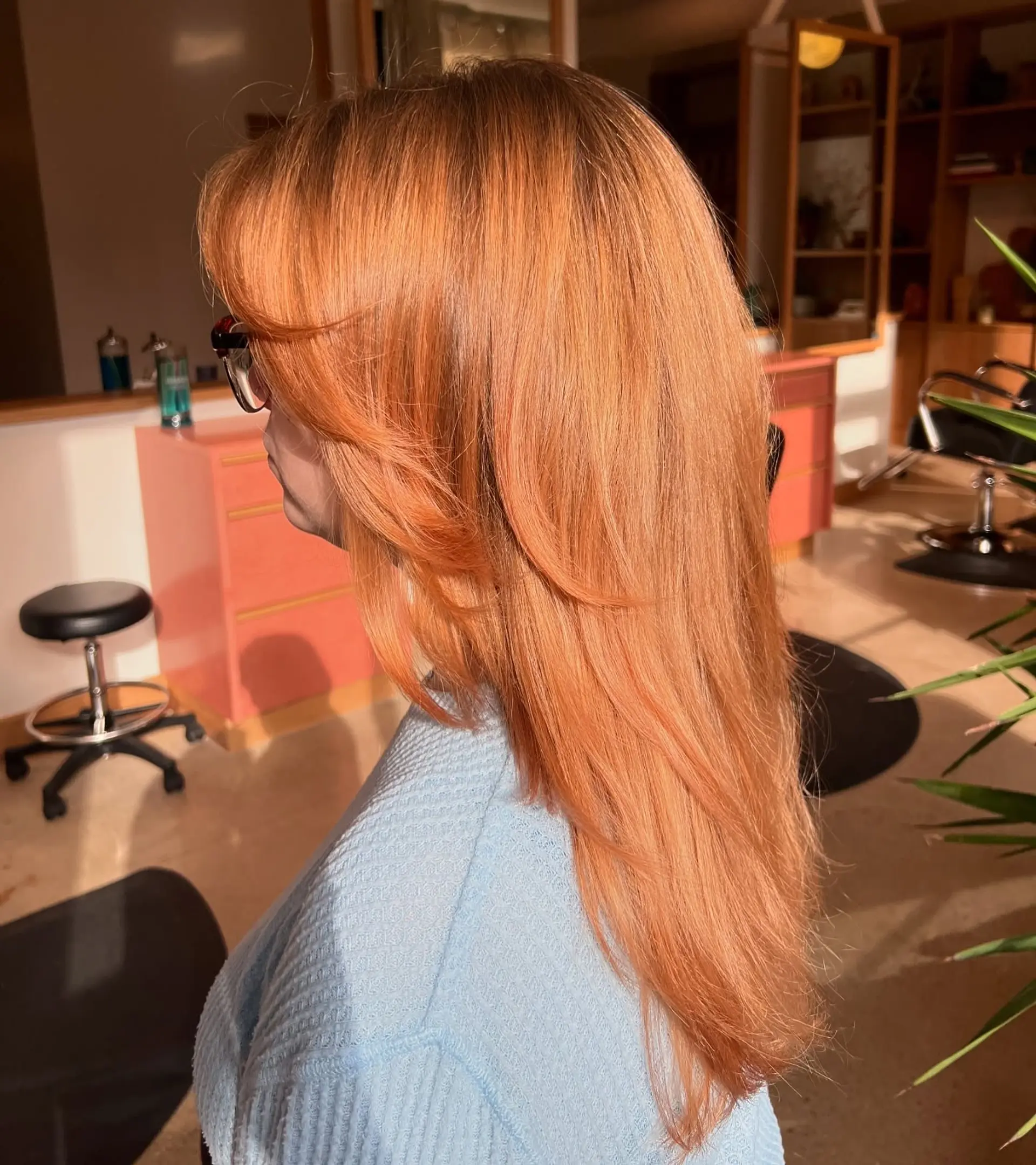 A stylish long layered haircut with a vibrant copper color, featuring face-framing layers. 1