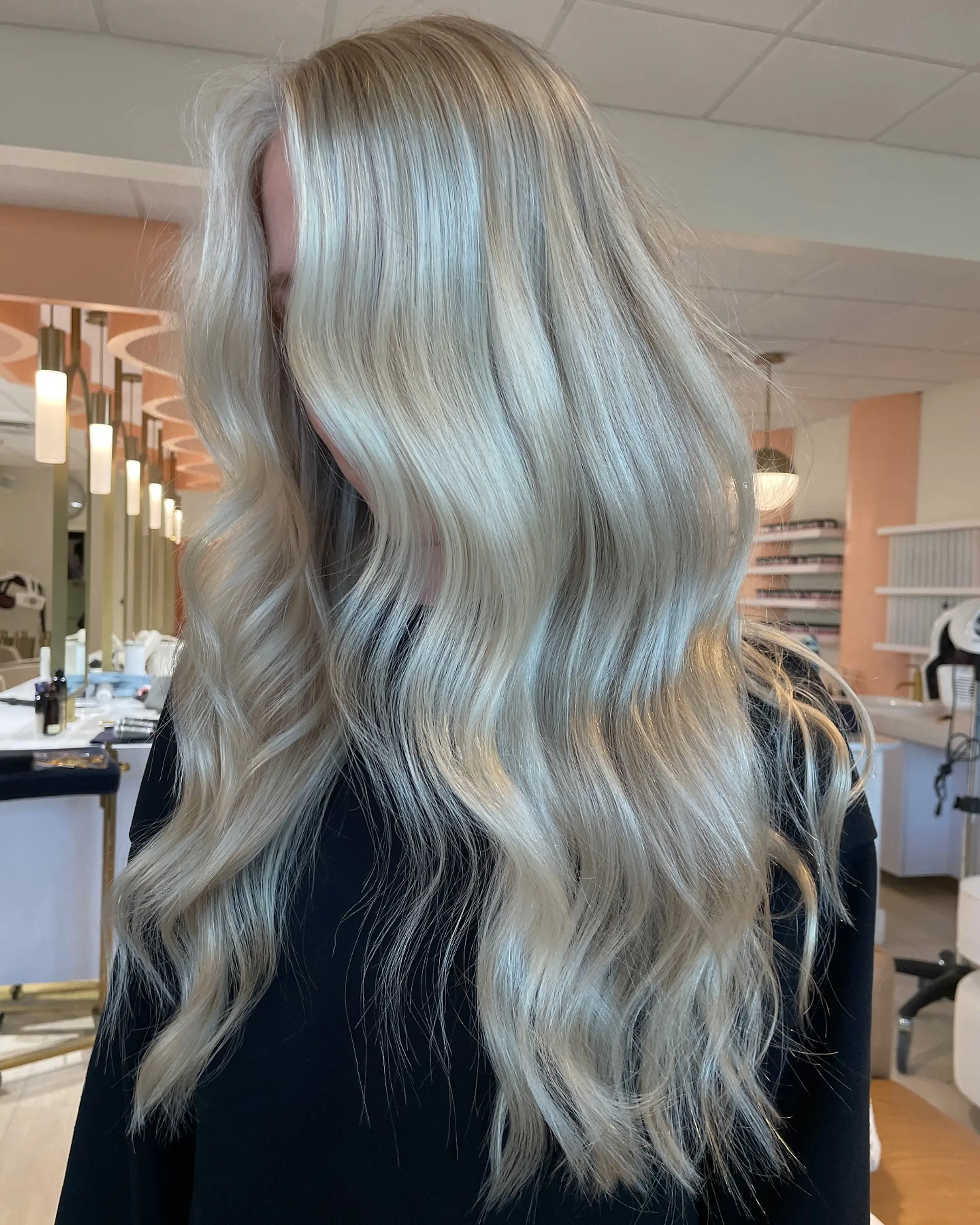 Long, bright creamy platinum blonde hair styled with soft, cascading waves and a smooth, glossy finish. 1