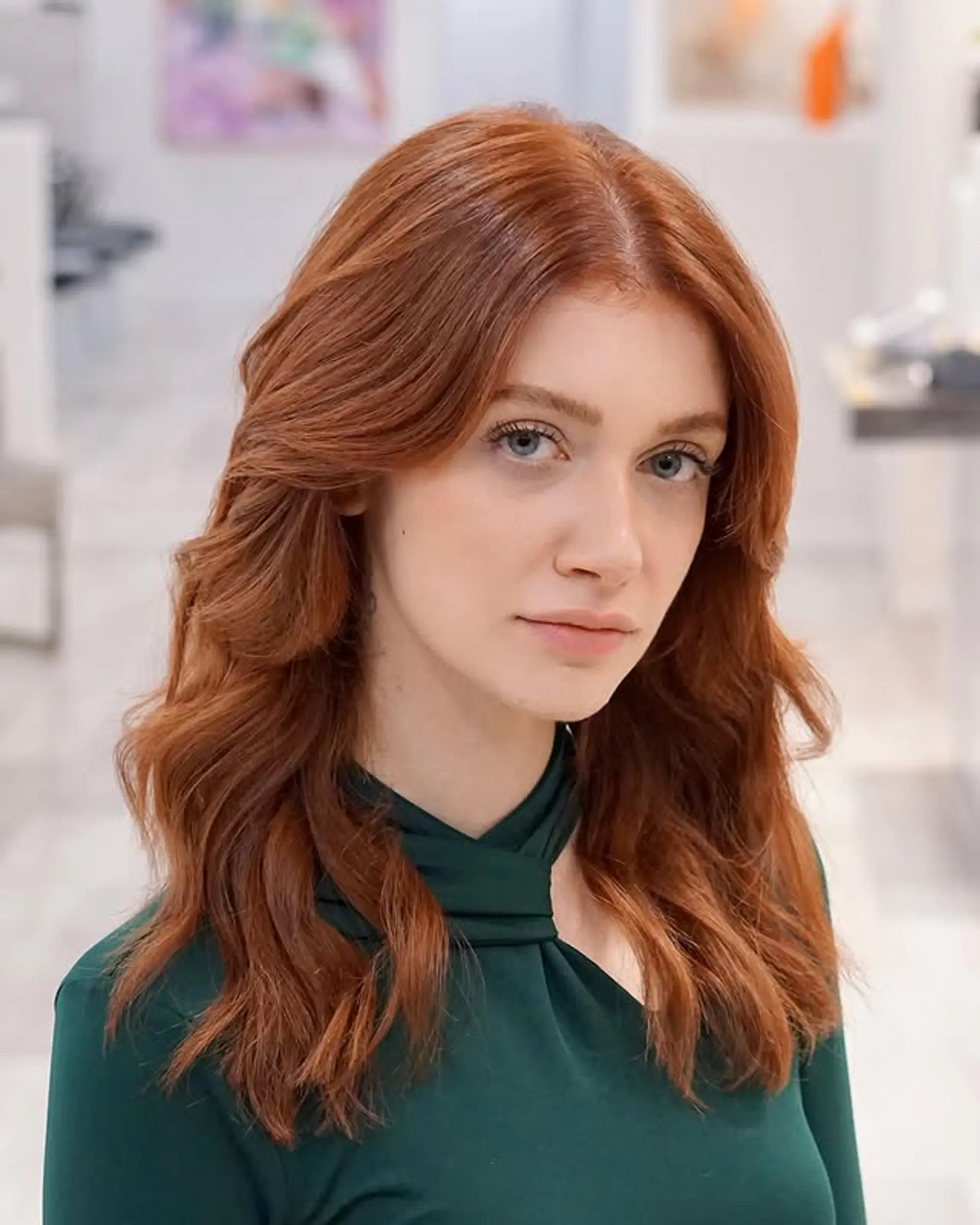 A medium-length wavy hairstyle with layers and face-framing pieces. 1