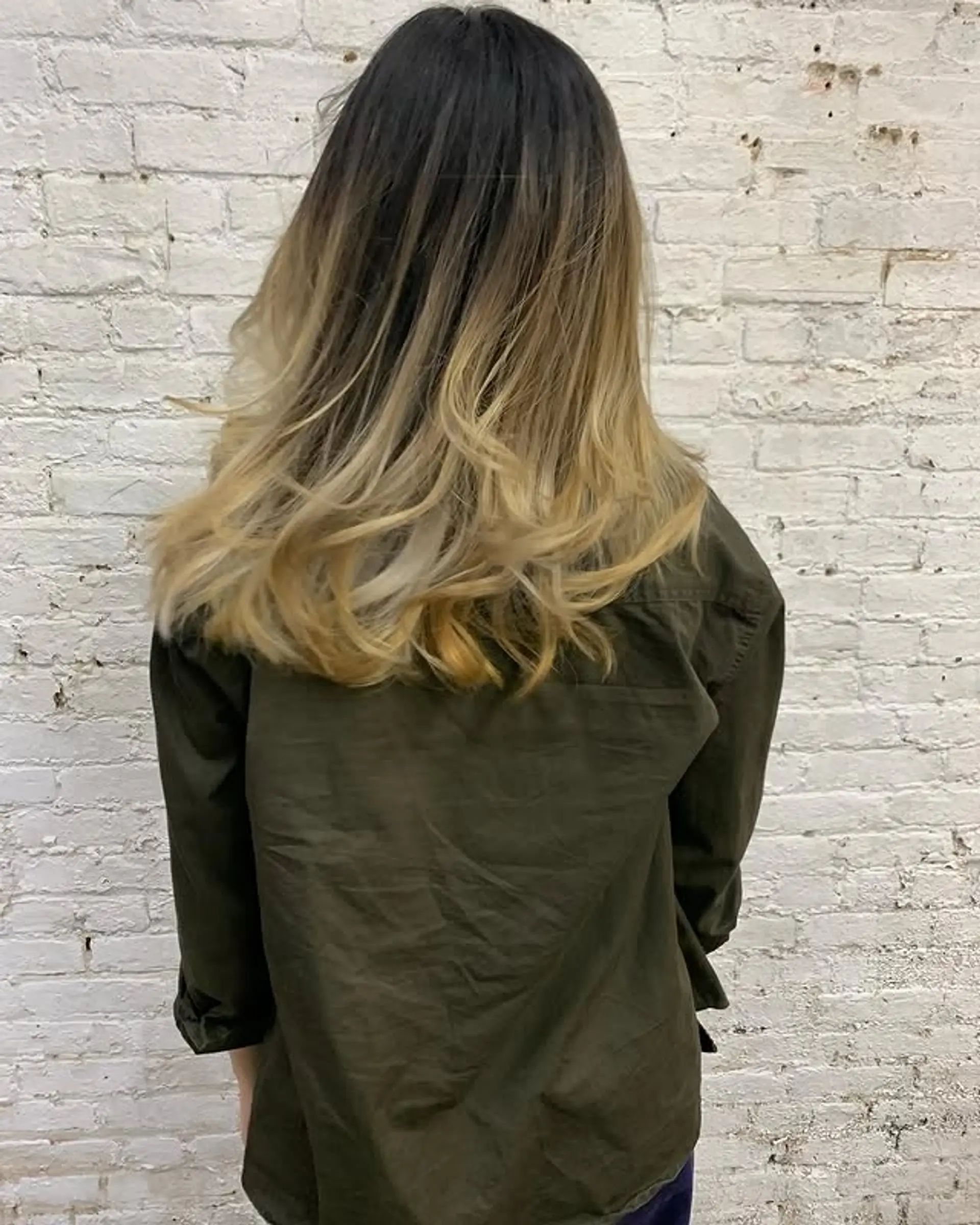 Long wavy hair with a black to blonde ombre and layered ends. 1