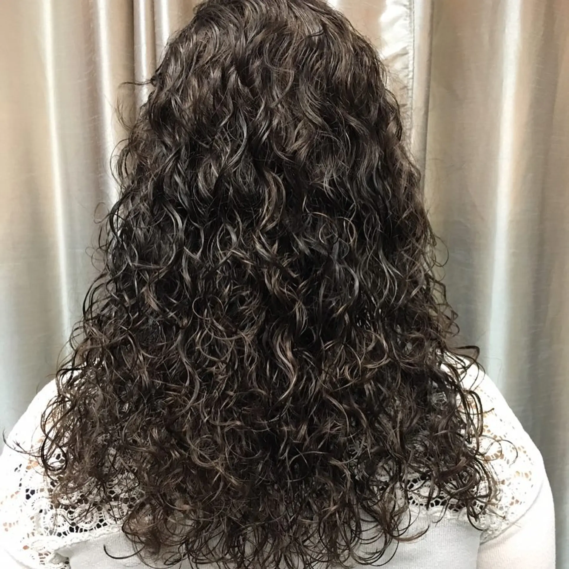 Long dark brown hair with defined natural curls cascading down the mid-back. 1