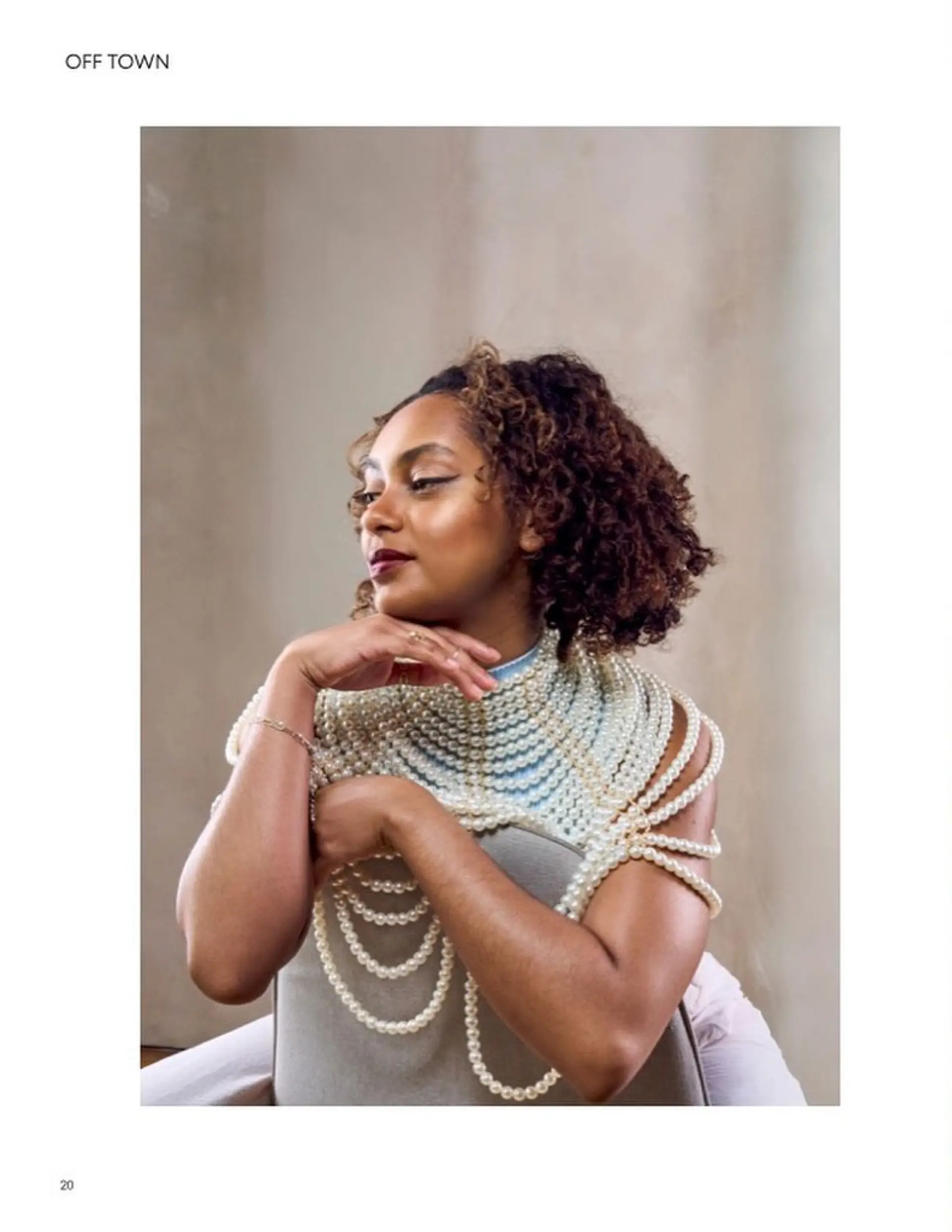 A defined, curly bob featuring warm caramel dimensional highlights and side-parted styling. 1