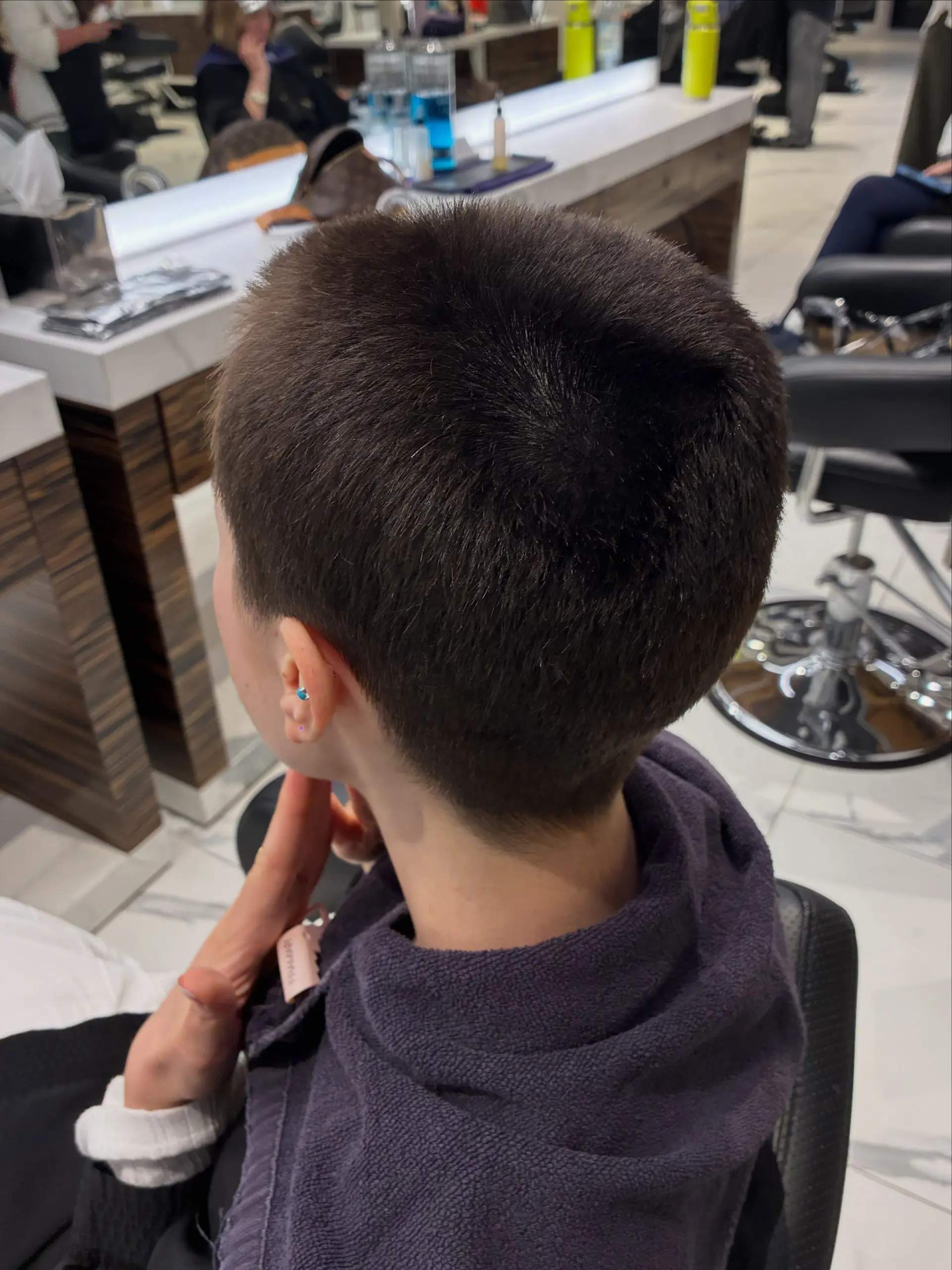 A close-cropped, uniform dark brown buzz cut with softly textured length on top. 1