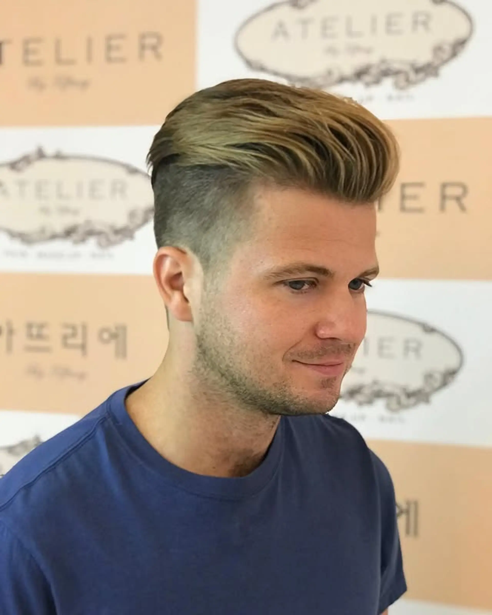 An undercut with a pompadour style on top and a fade on the sides. 1