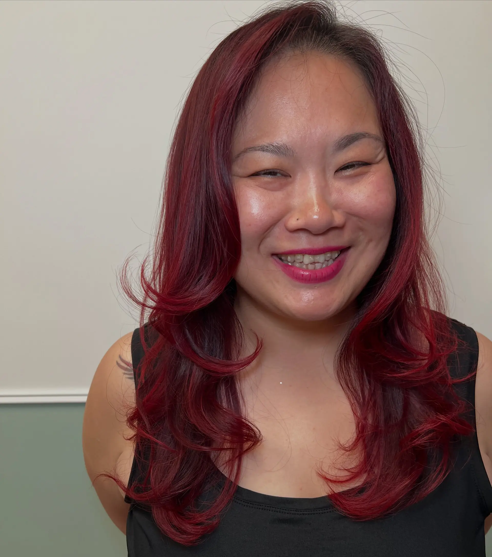 Long vibrant red hair cut with face-framing layers and styled in a bouncy blowout. 1