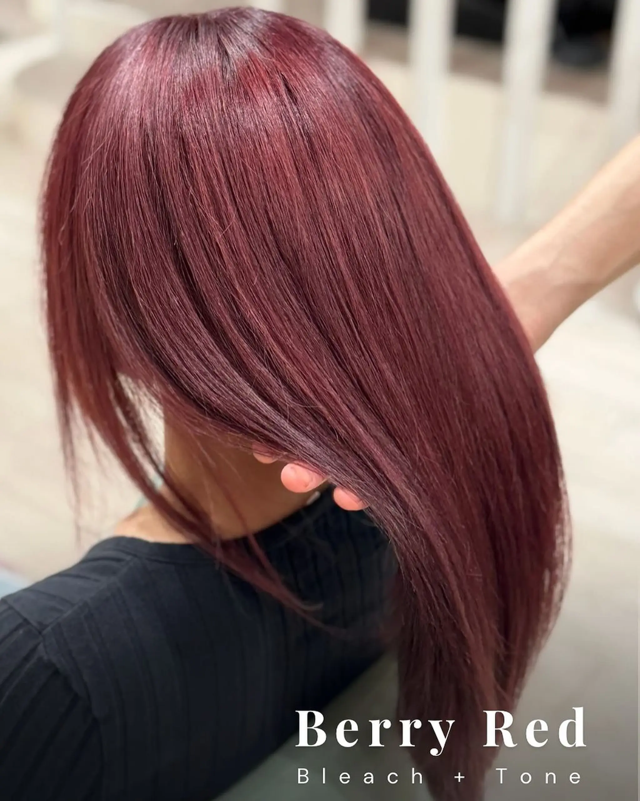 The model features a vibrant berry red hair color that is both striking and eye-catching. The hair is straight and falls long, creating a sleek and polished look.