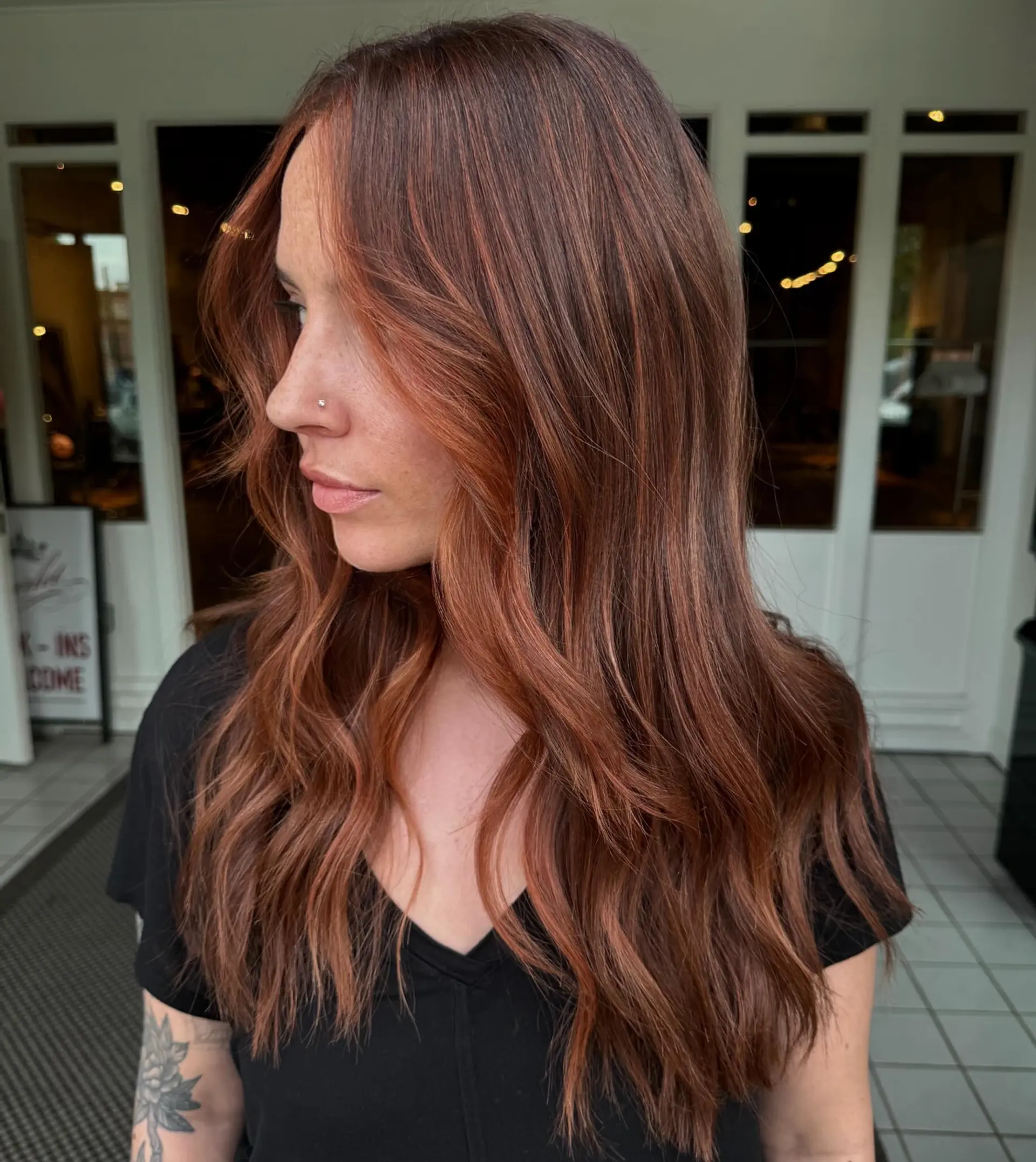Long warm auburn hair styled in soft, cascading waves with subtle copper face-framing highlights. 1