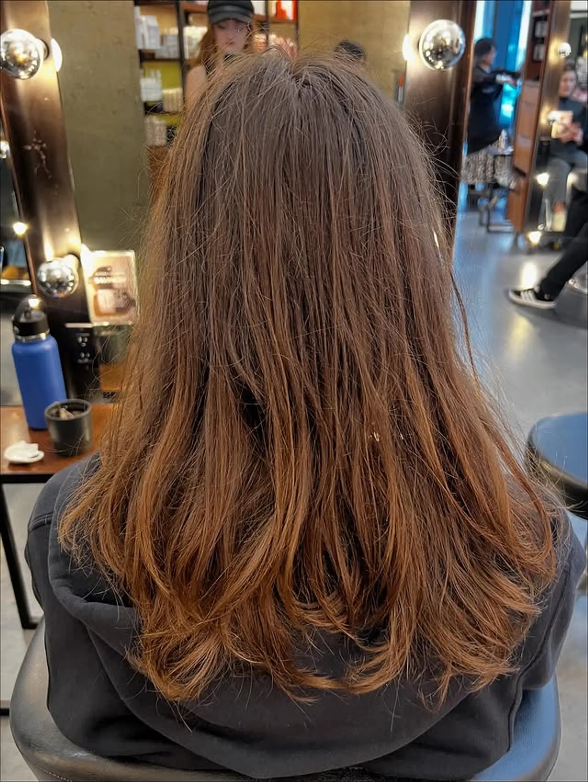 Long layered haircut with soft auburn balayage highlights. 1