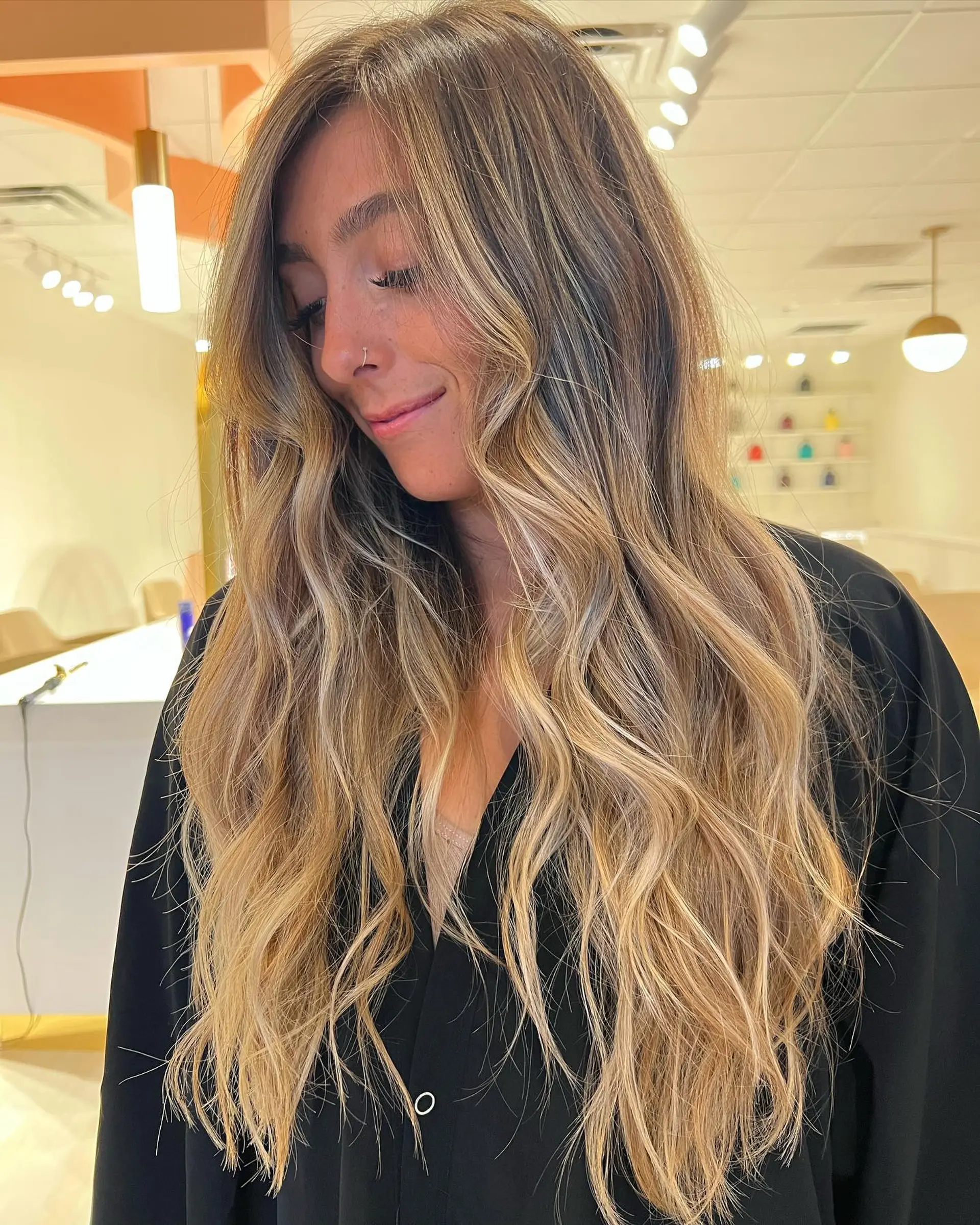 Extra-long hair featuring a sun-kissed blonde balayage with seamless root blending and soft, undone waves. 1