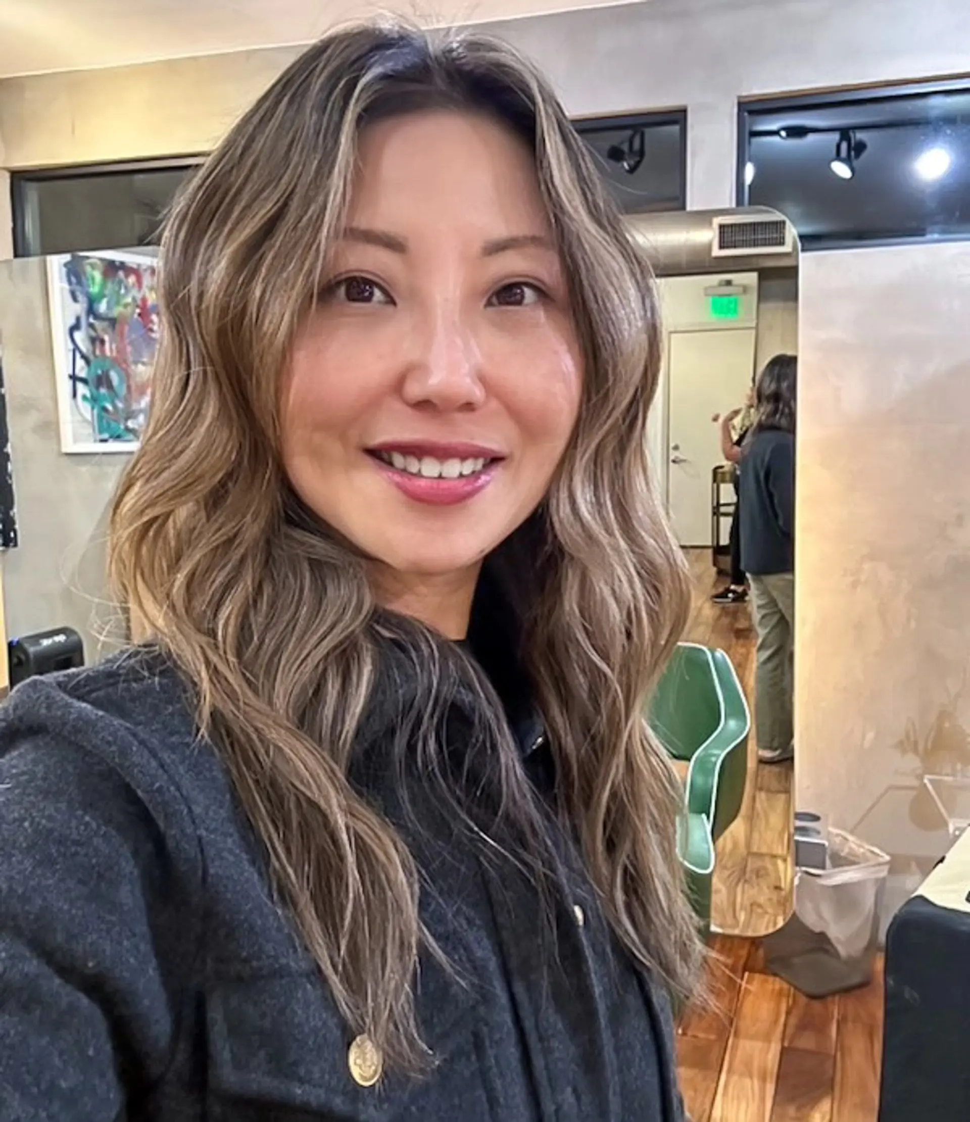 Long ash blonde highlights styled into soft, flowing textured waves with a center part. 1