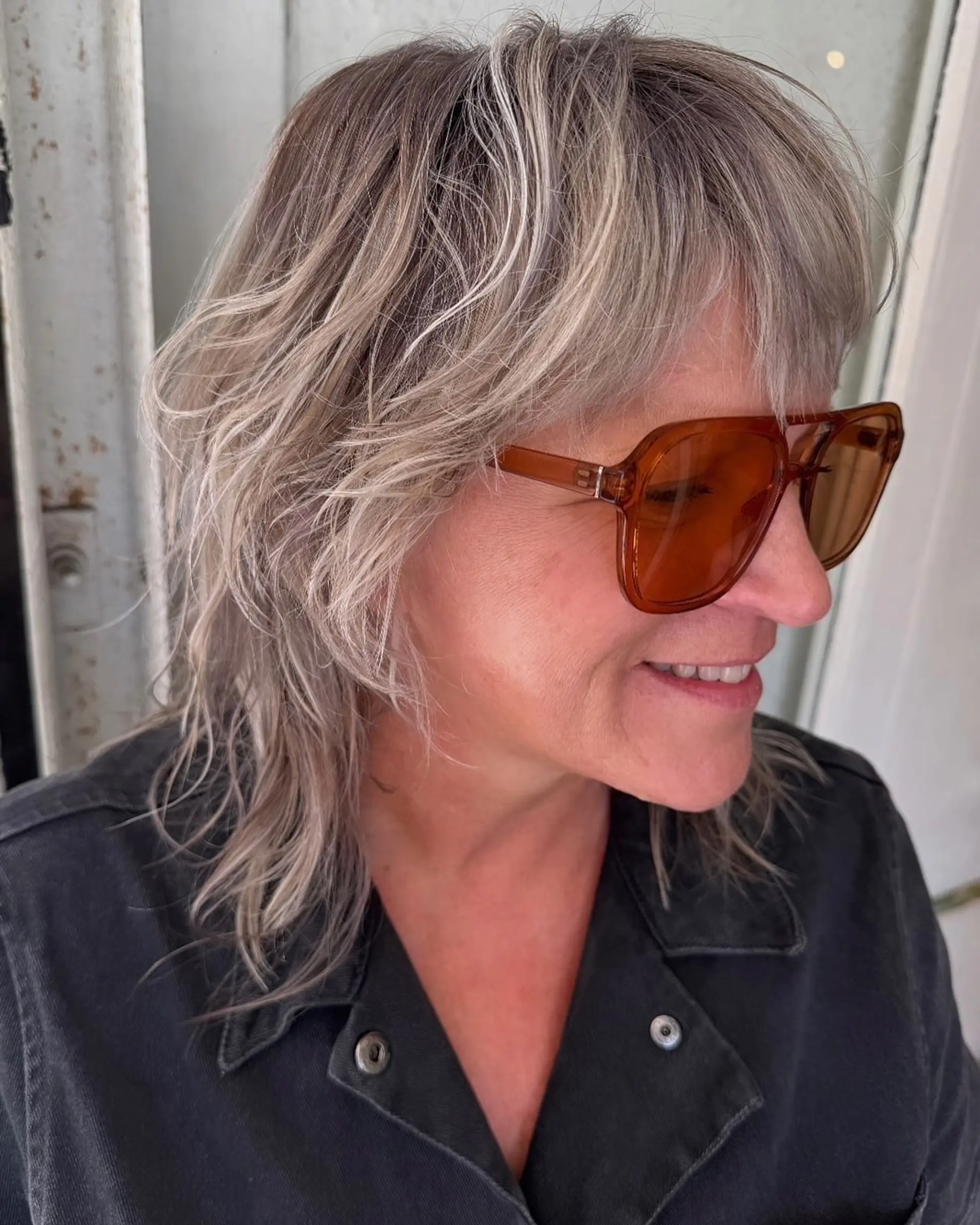 Medium-length wavy hair with silver and ash blonde tones, textured layers, and natural waves. 3