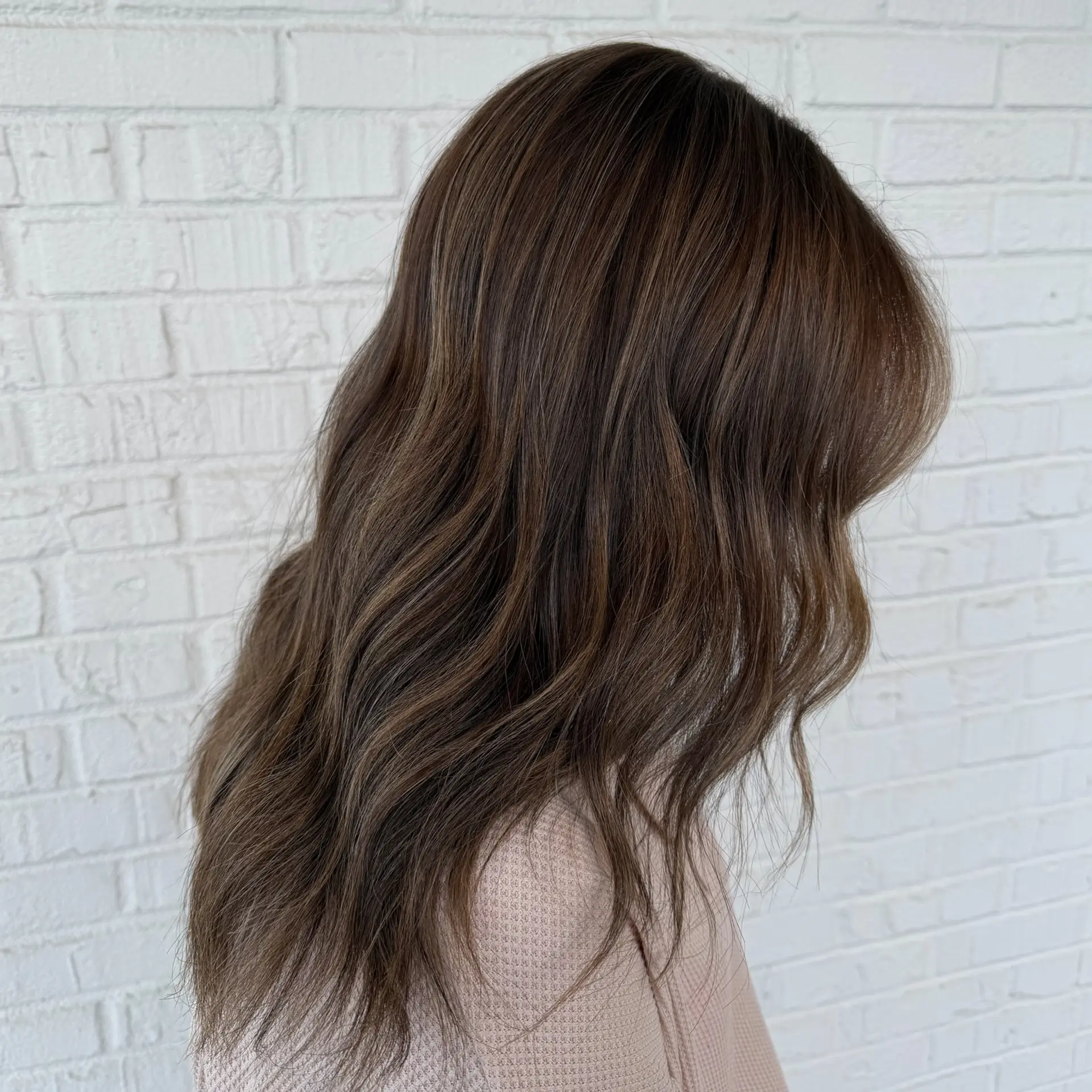 Rich, multi-dimensional hot cocoa brunette styled into soft, relaxed waves cascading past the shoulders. 1