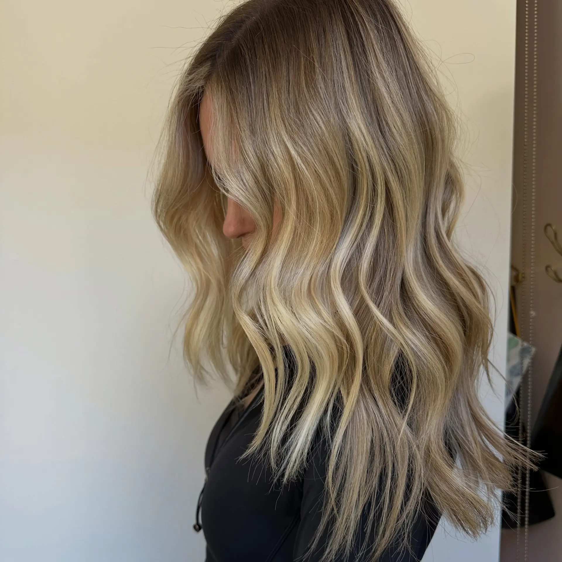 Dimensional lived-in blonde balayage with a rooted blend, styled into loose, textured waves. 1