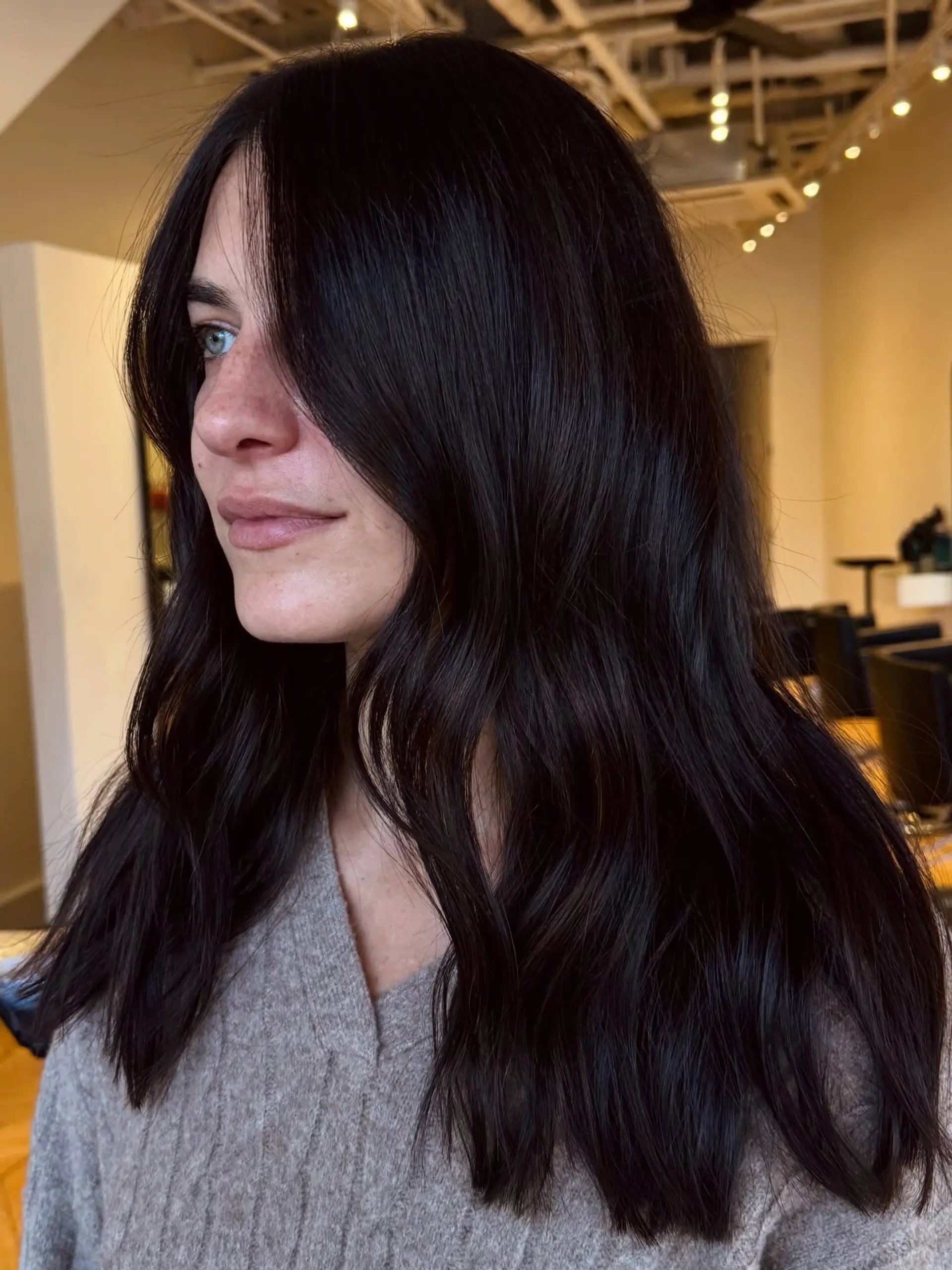 Long, rich dark brunette hair styled in loose, soft waves with face-framing layers. 1