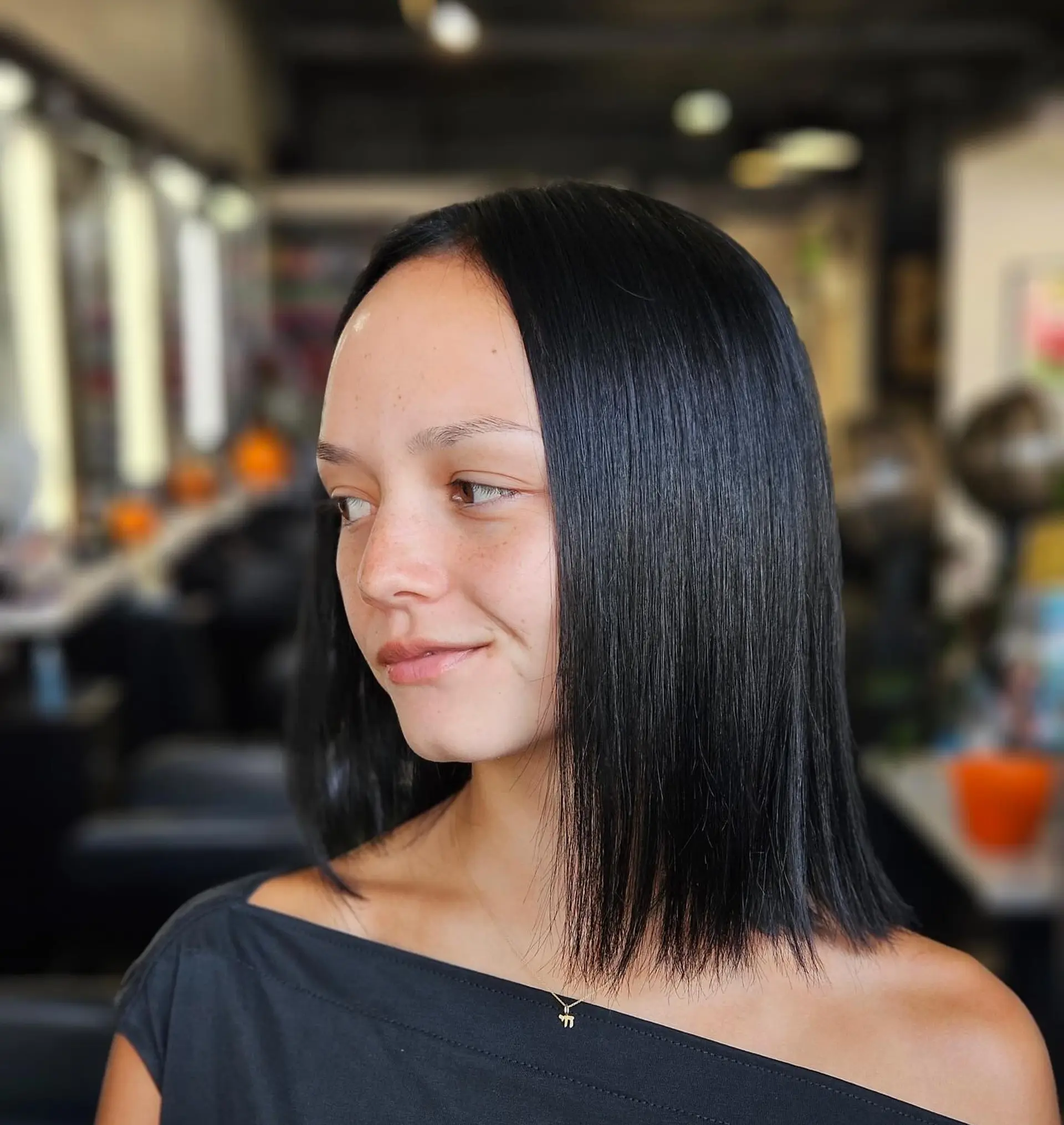 A sleek, shoulder-length blunt lob dyed in a rich, glossy jet black tone and styled pin-straight. 1