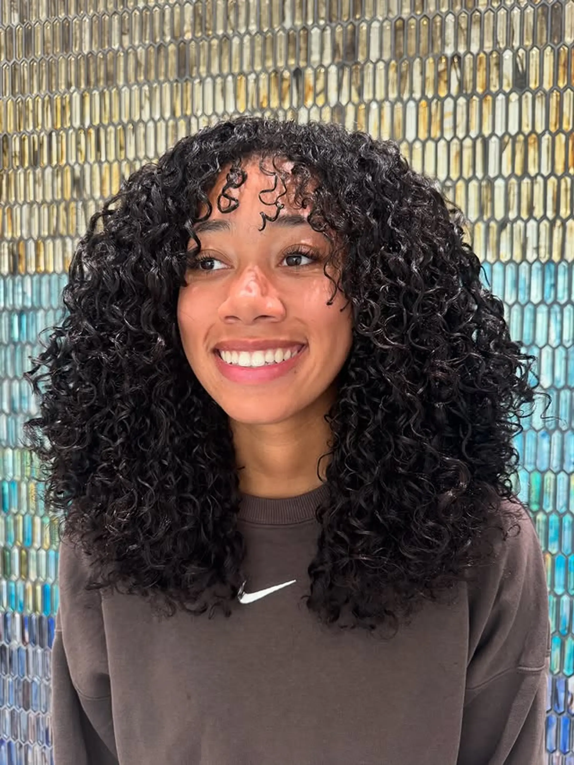 A medium-length curly bob with curly bangs, perfect for showcasing natural texture and defined curls. 1