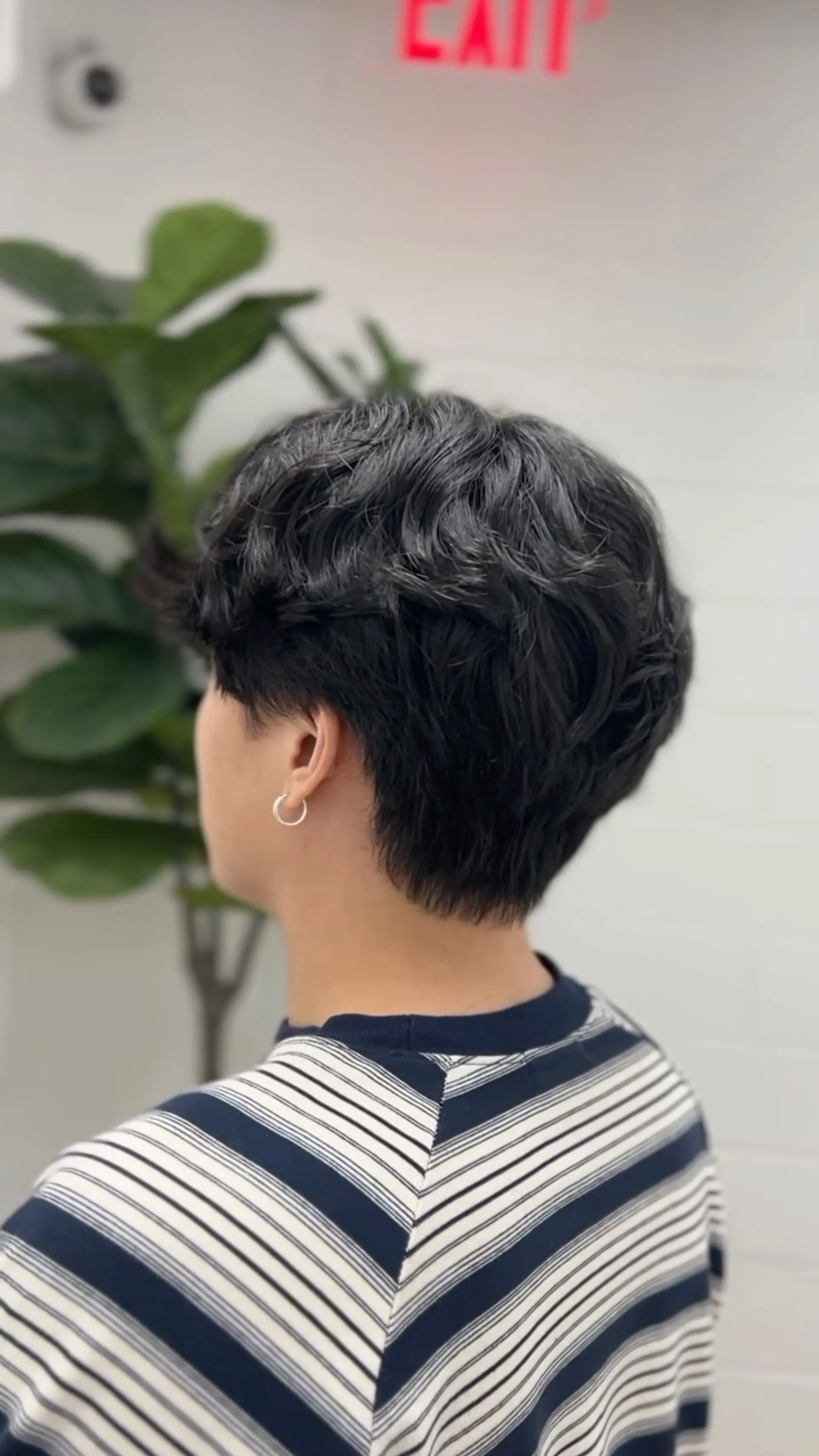 A textured short haircut featuring soft, defined waves on top with tapered sides and nape. 1