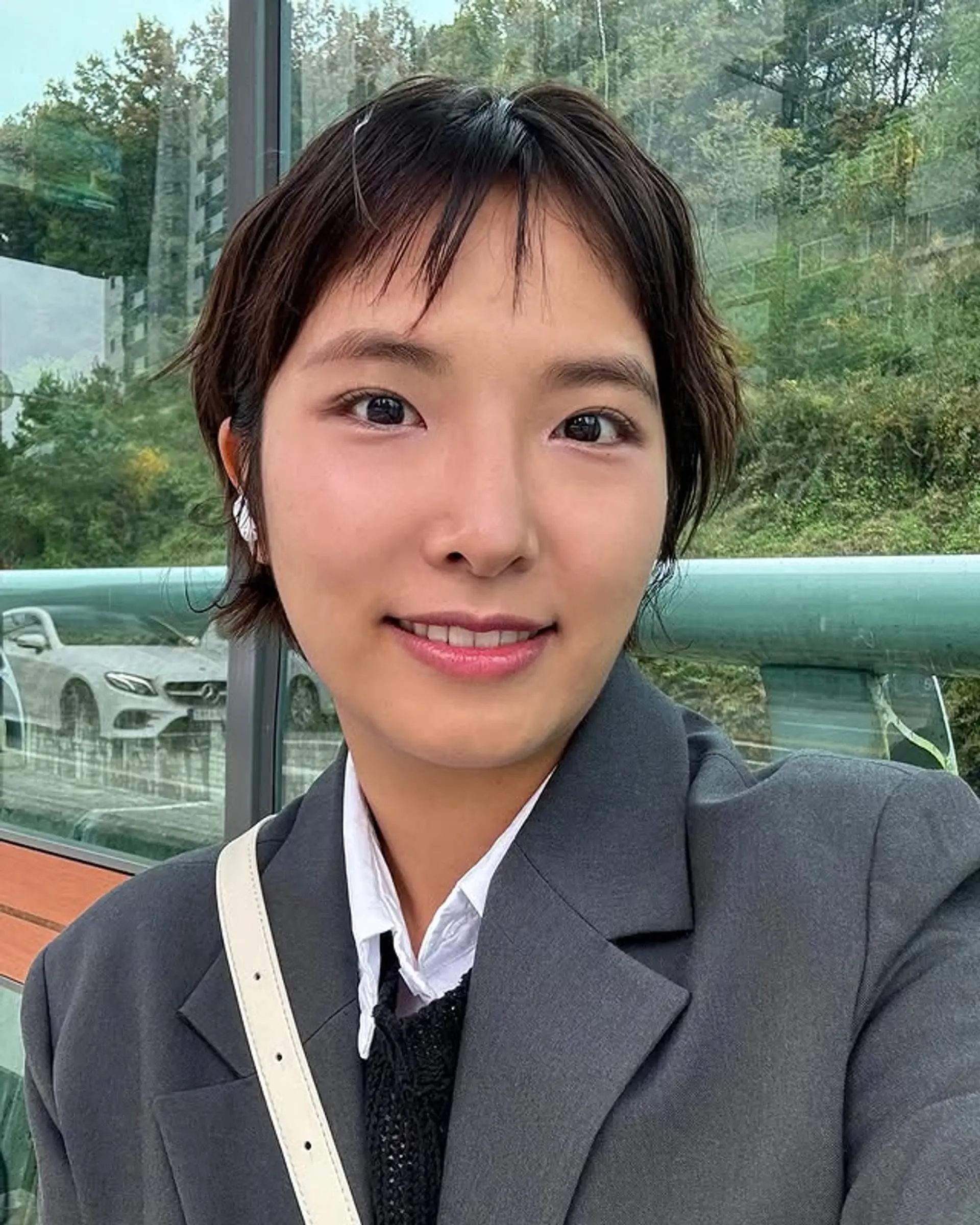 A modern shaggy pixie cut characterized by its short length, textured layers, and edgy choppy bangs that frame the face for a stylish and low-maintenance look. 1