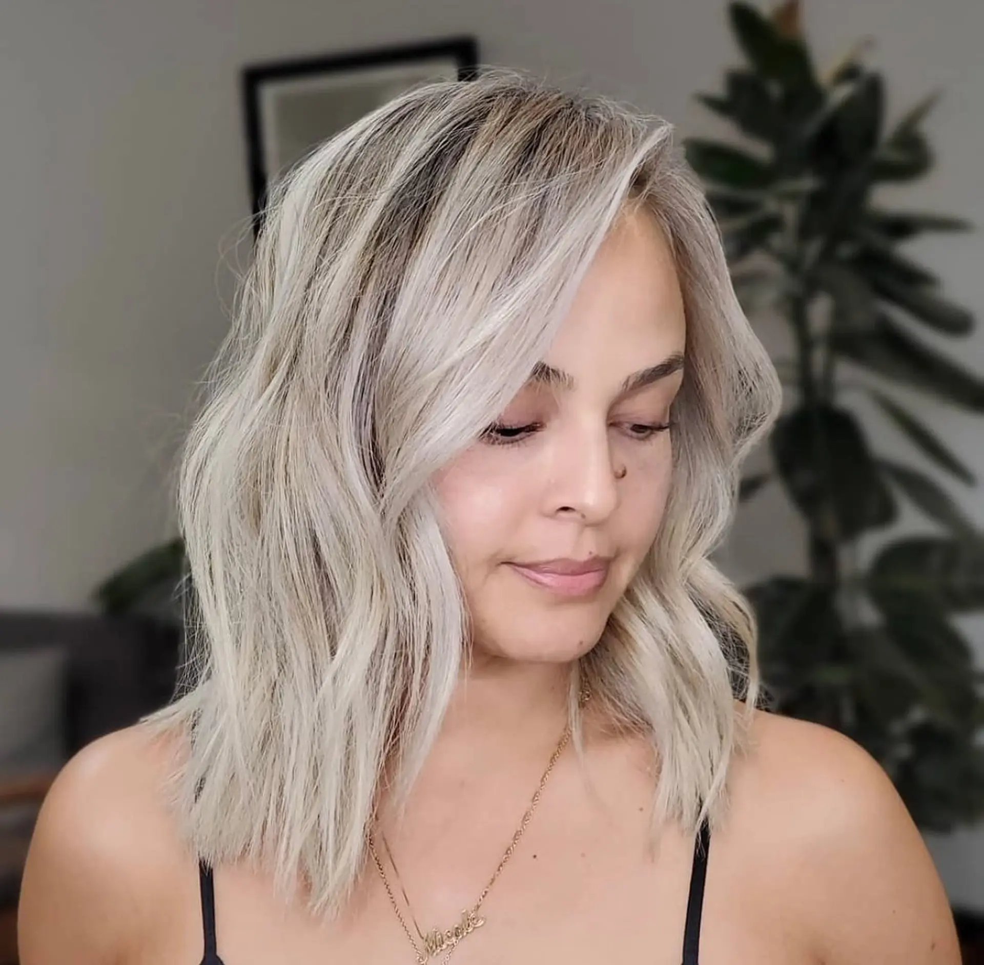 A textured shoulder-length lob styled in loose waves with an icy, ultra-cool platinum blonde shade. 1
