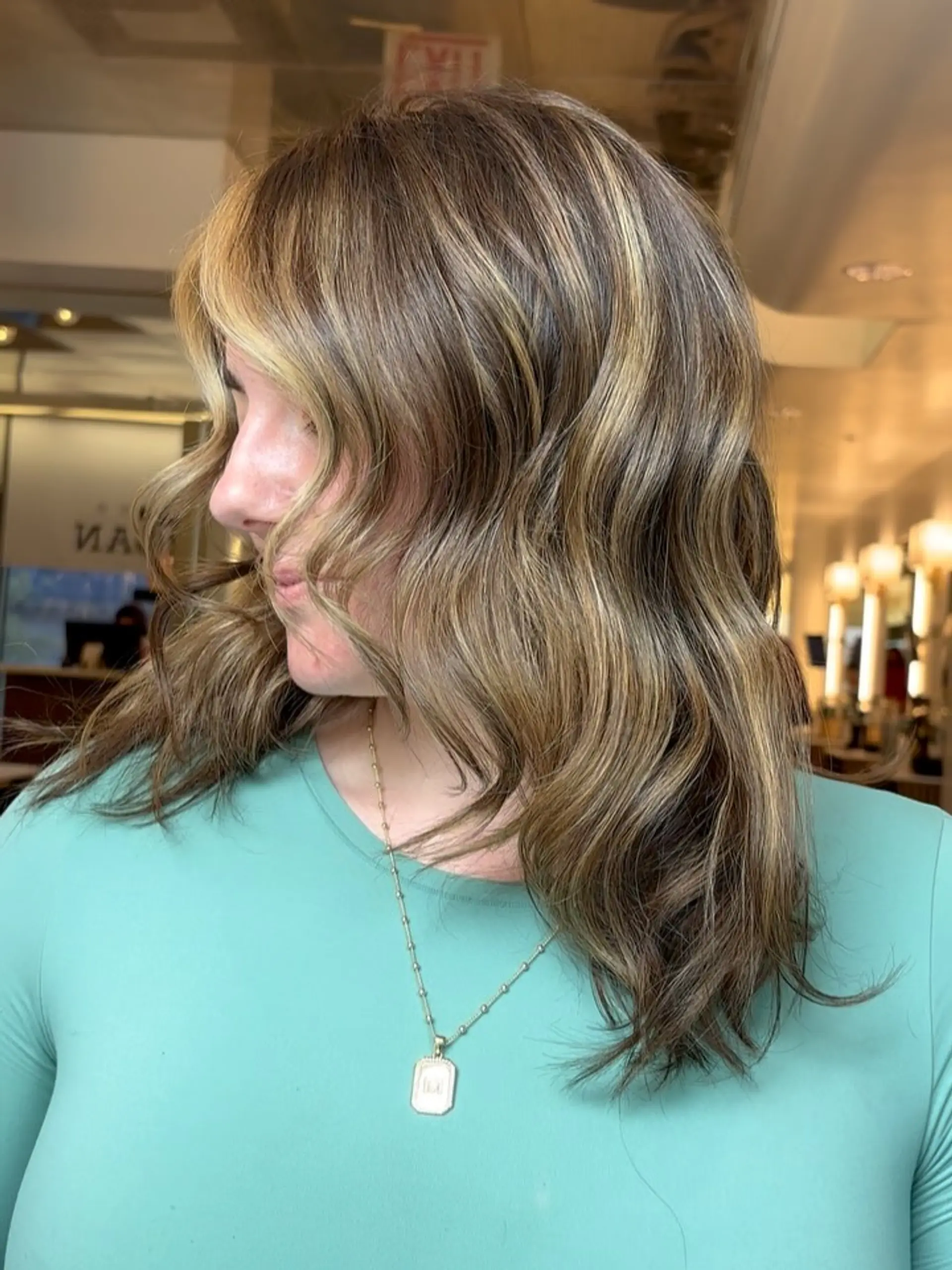Medium-length dimensional brunette hair styled in relaxed, textured waves with face-framing highlights. 1