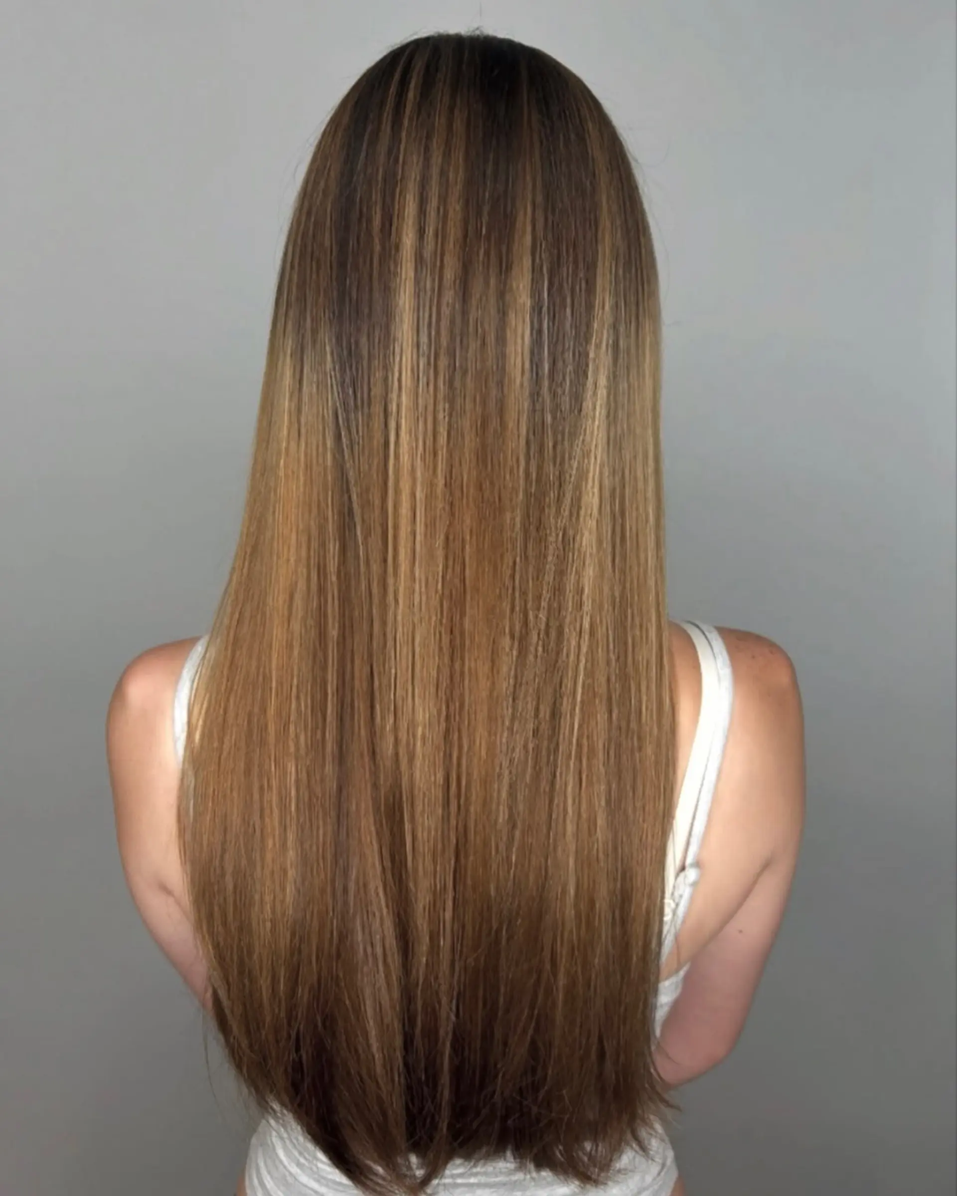 Sleek, extra-long straight hair featuring warm caramel and golden highlights blended over a light brown base. 1