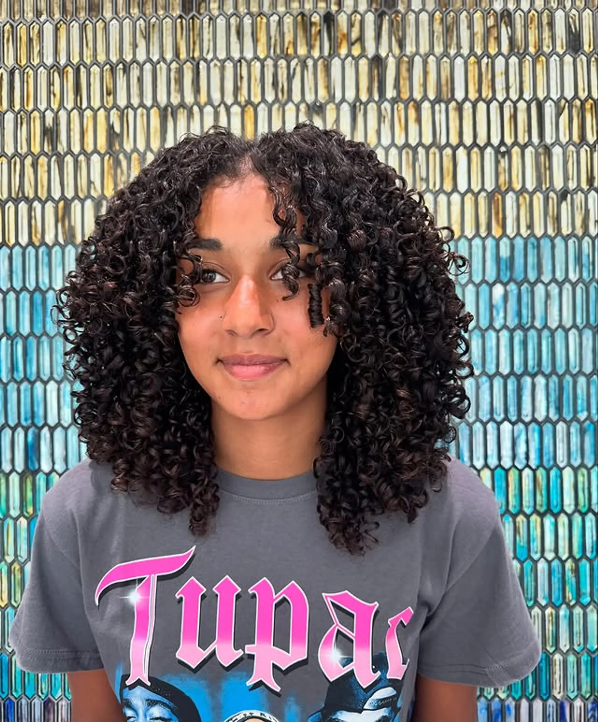 A trendy medium-length shag haircut designed to enhance natural curls and create a layered, voluminous look. 1