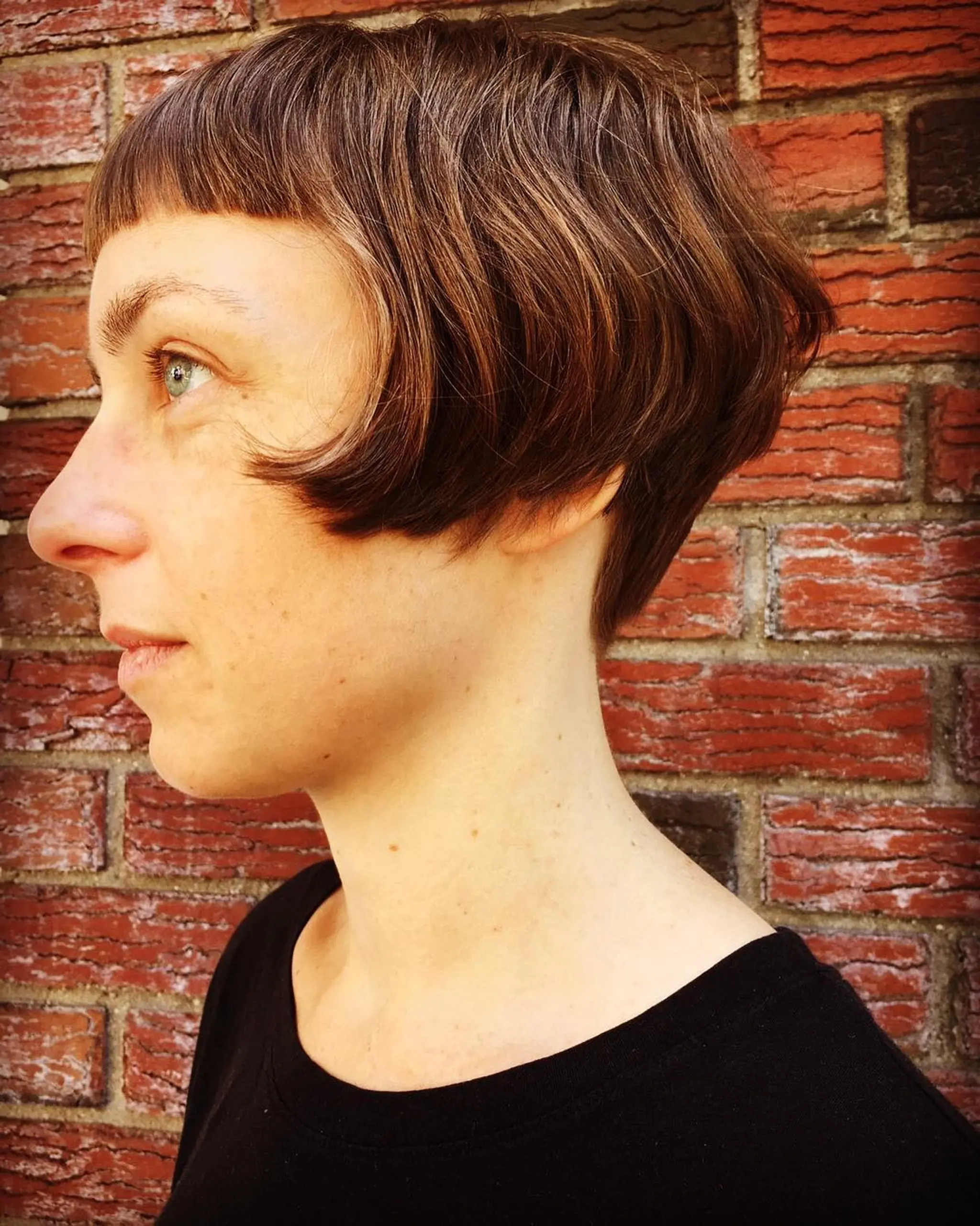 Short bob cut with wavy texture, subtle fringe detailing, and a tapered nape for a vintage-inspired yet modern look.
