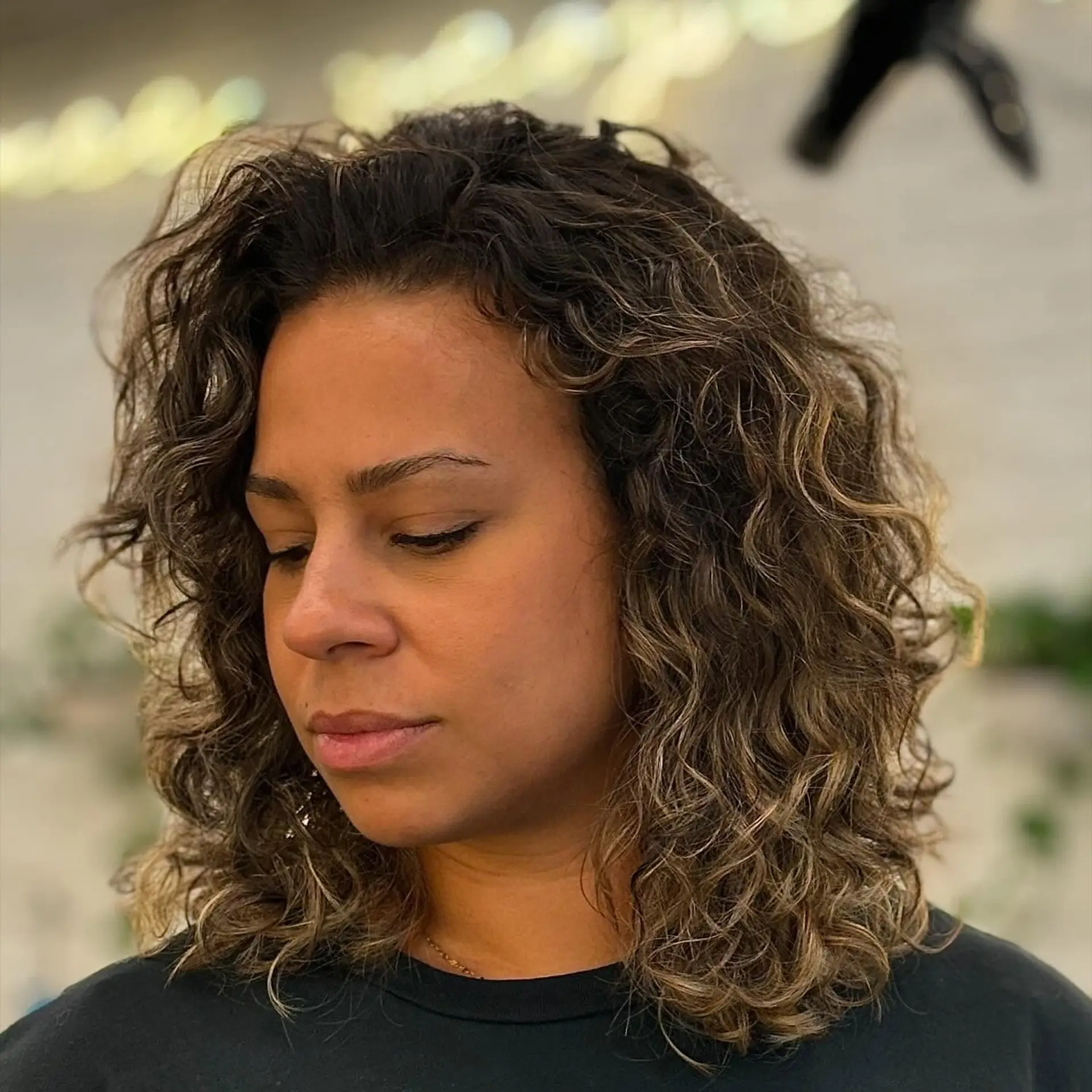 A medium-length curly shag with textured layers and a subtle balayage. 1