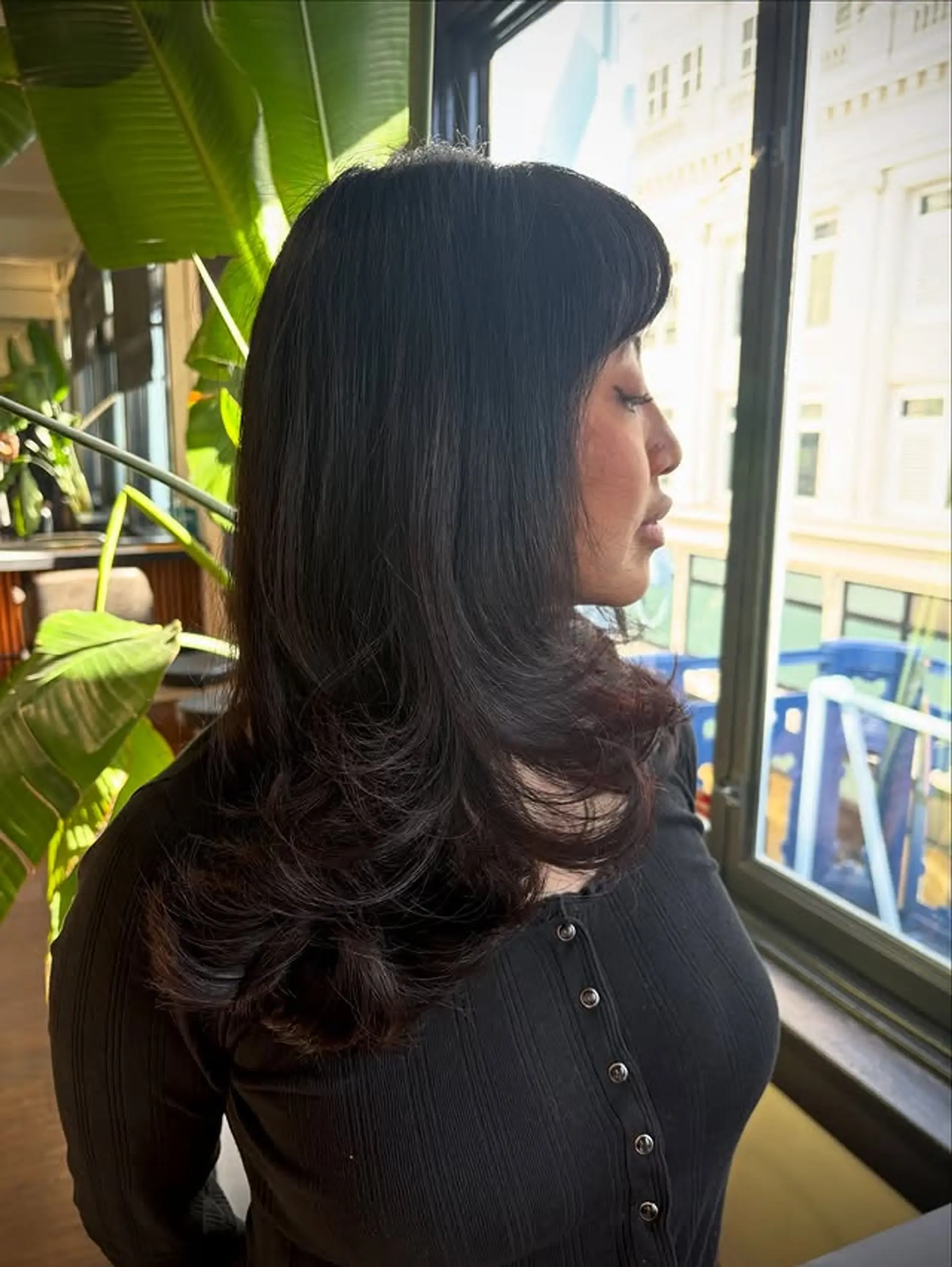 A medium-length layered haircut with soft bangs. 1