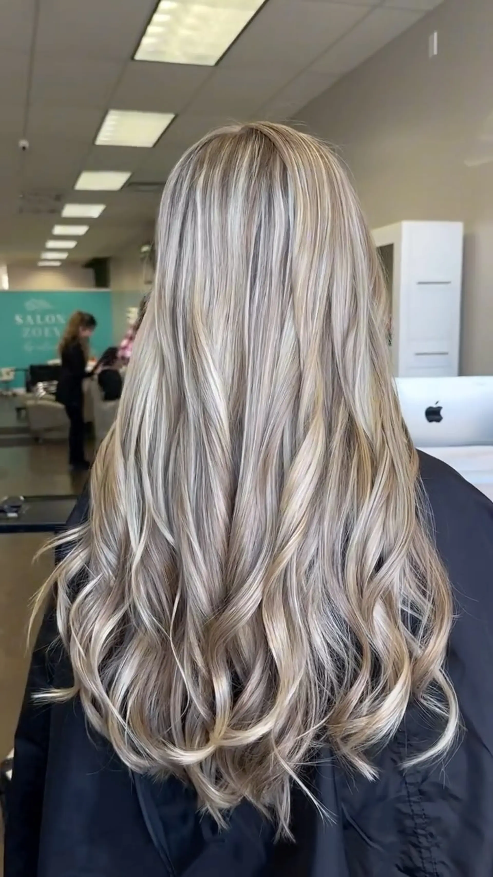 Long hair with fine ash blonde highlights throughout, styled smooth at the crown and cascading into soft iron curls at the ends. 1