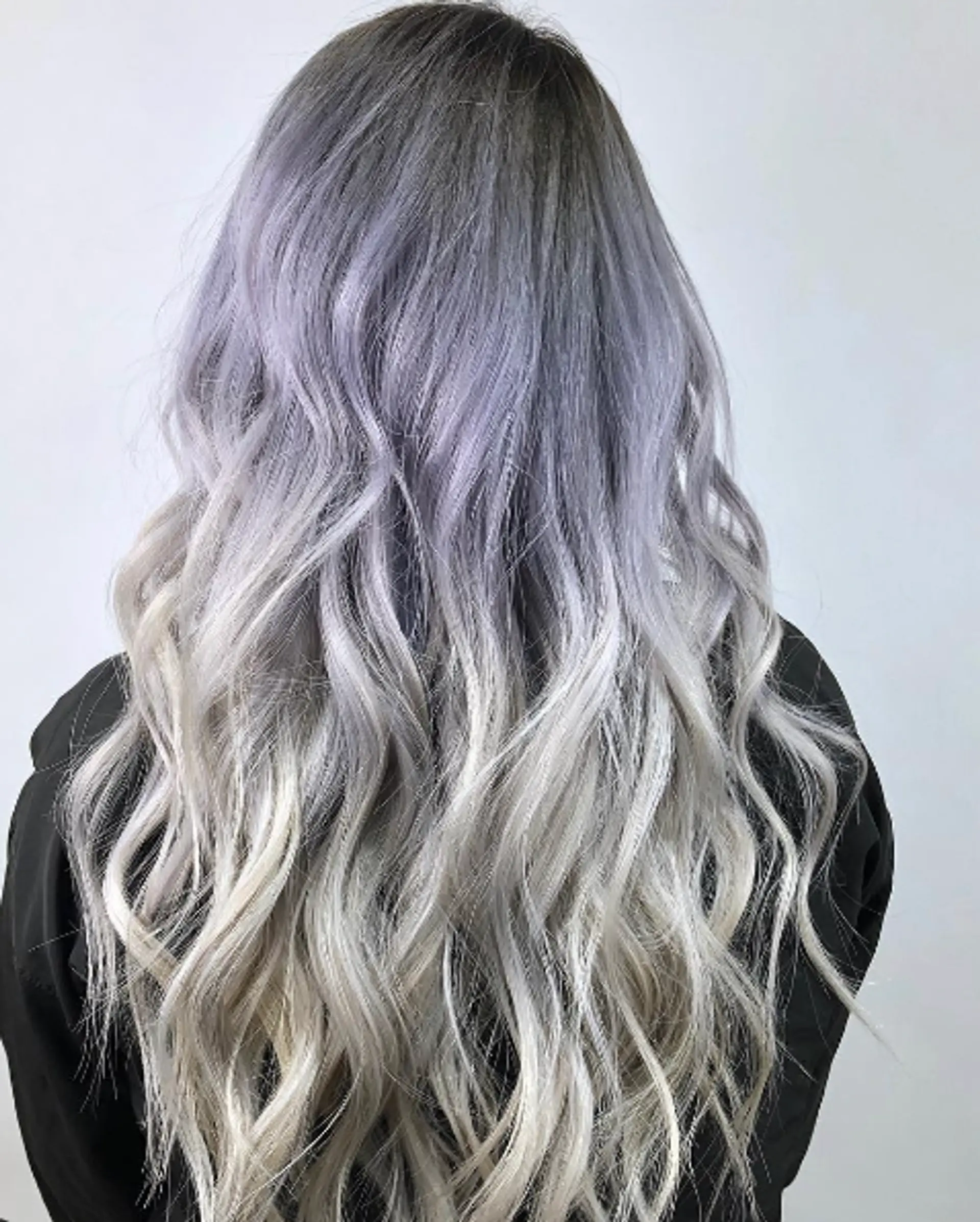 Very long, wavy hair with a gradient ombre starting from gray at the roots, transitioning through lavender to platinum at the ends, featuring soft waves and cool tones. 1