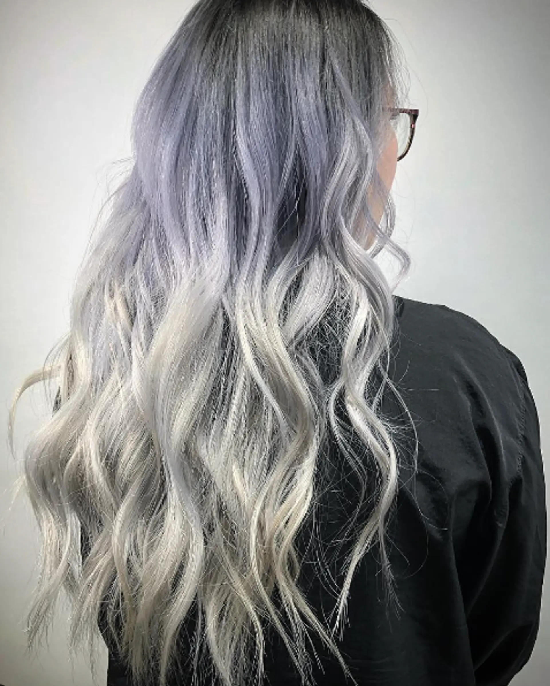 Very long, wavy hair with a gradient ombre starting from gray at the roots, transitioning through lavender to platinum at the ends, featuring soft waves and cool tones. 2