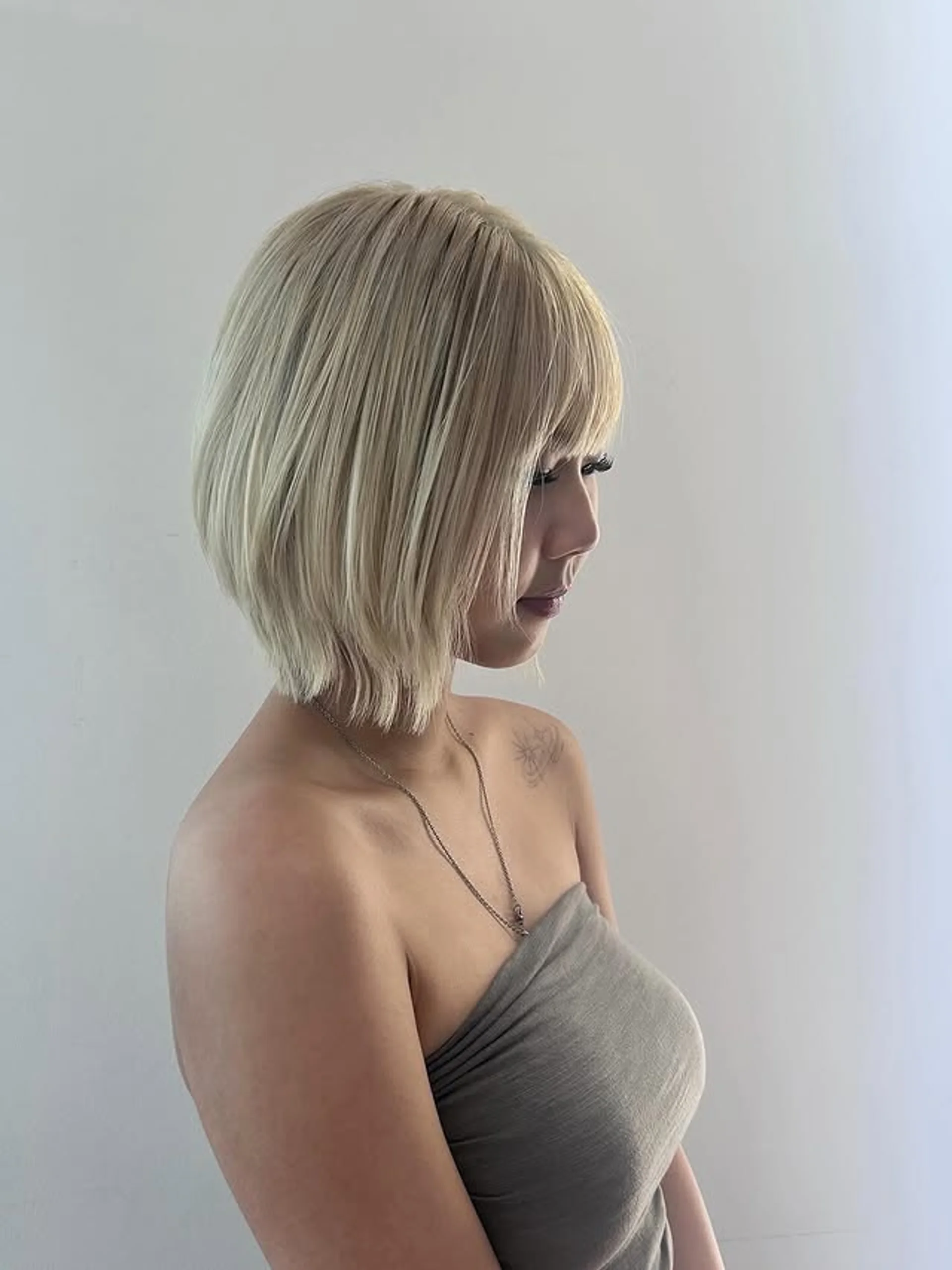 Vibrant tangerine blunt bob with sharp, straight-across bangs, making a bold statement. - Preview 3