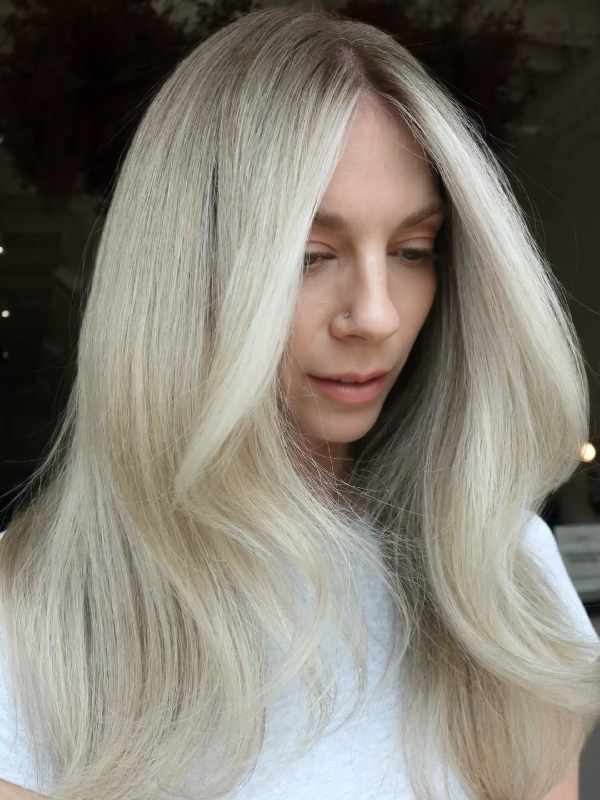 Bright neutral platinum blonde hair with a soft rooted effect, face-framing money piece, and smooth blowout layers. 1