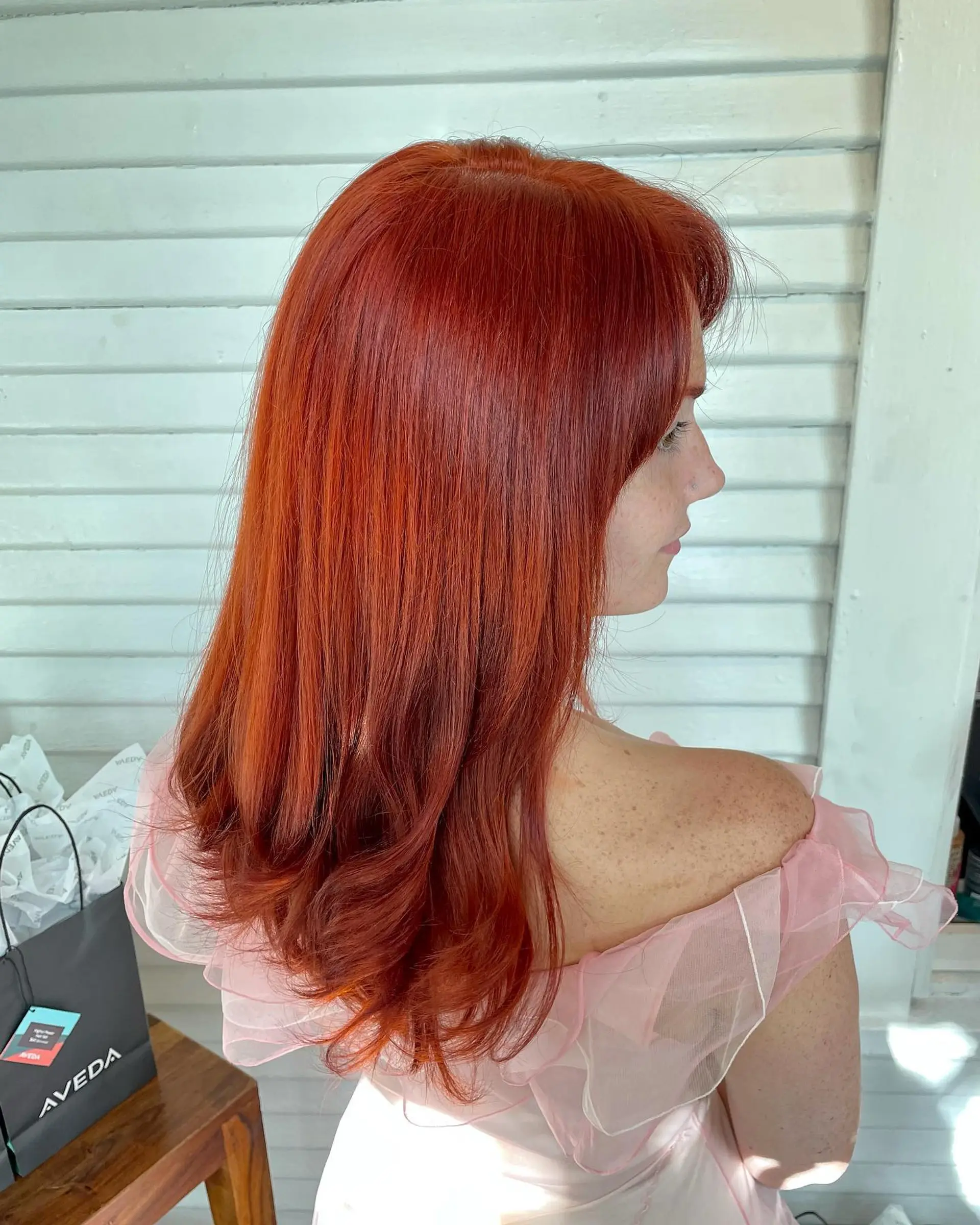 Vibrant copper-red hair styled smooth and sleek with soft, curled-under ends. 1