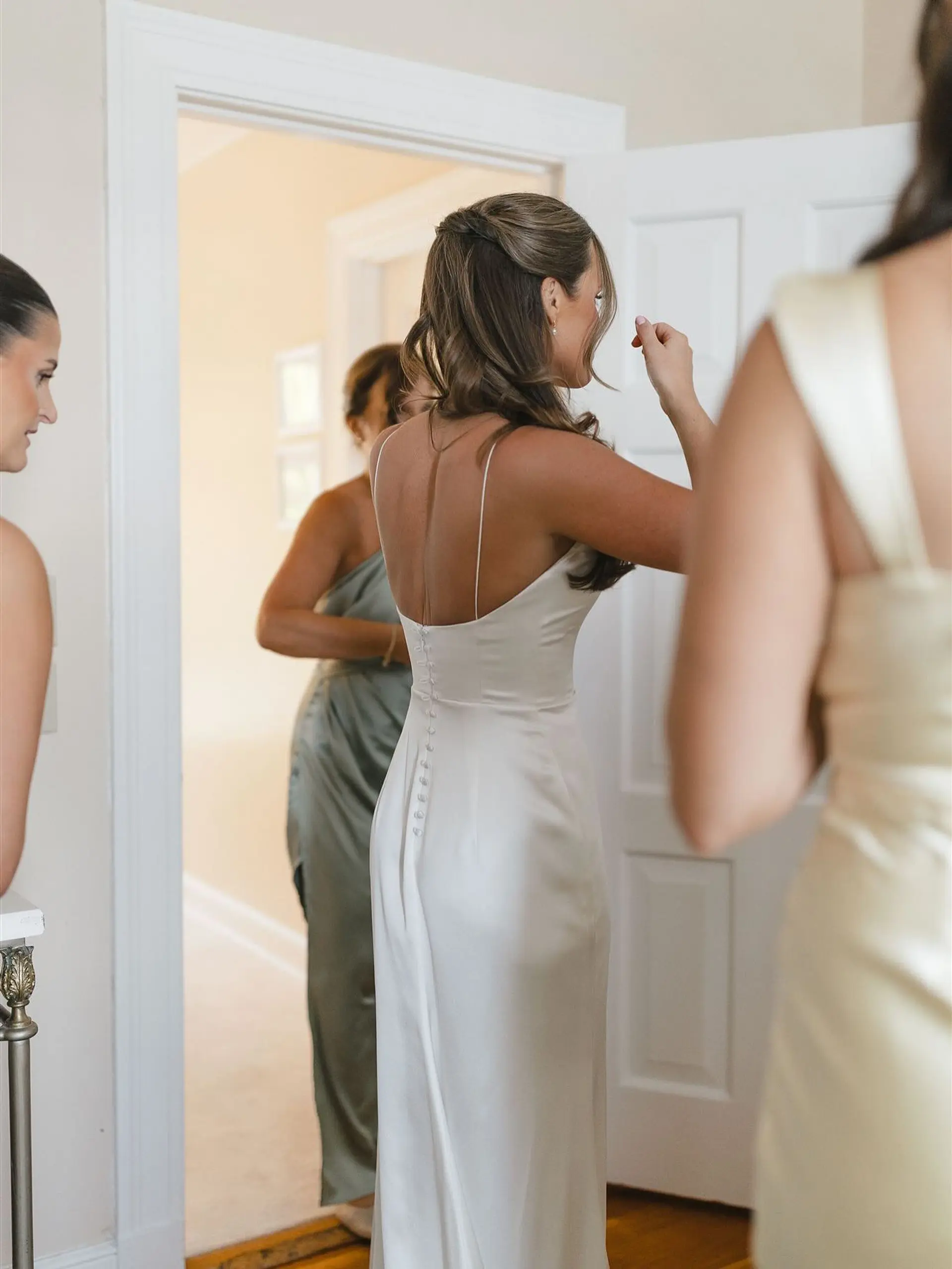 A romantic bridal half-up hairstyle featuring pulled-back side sections and soft, flowing waves cascading down the back. 1