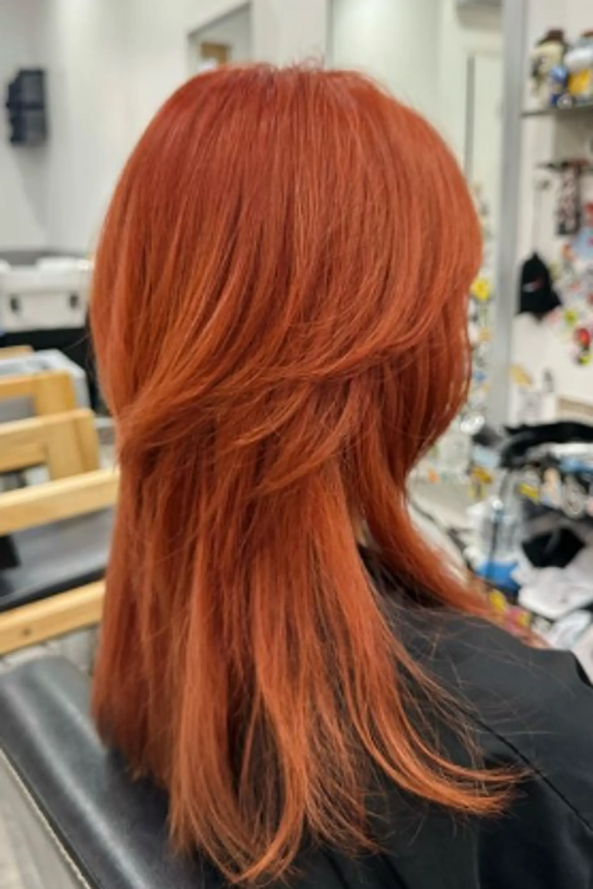 A vibrant, medium-length hairstyle with straight texture. The hair features fiery red and copper hues, layered cuts with a feathery texture, and blunt ends, offering movement and volume. 1