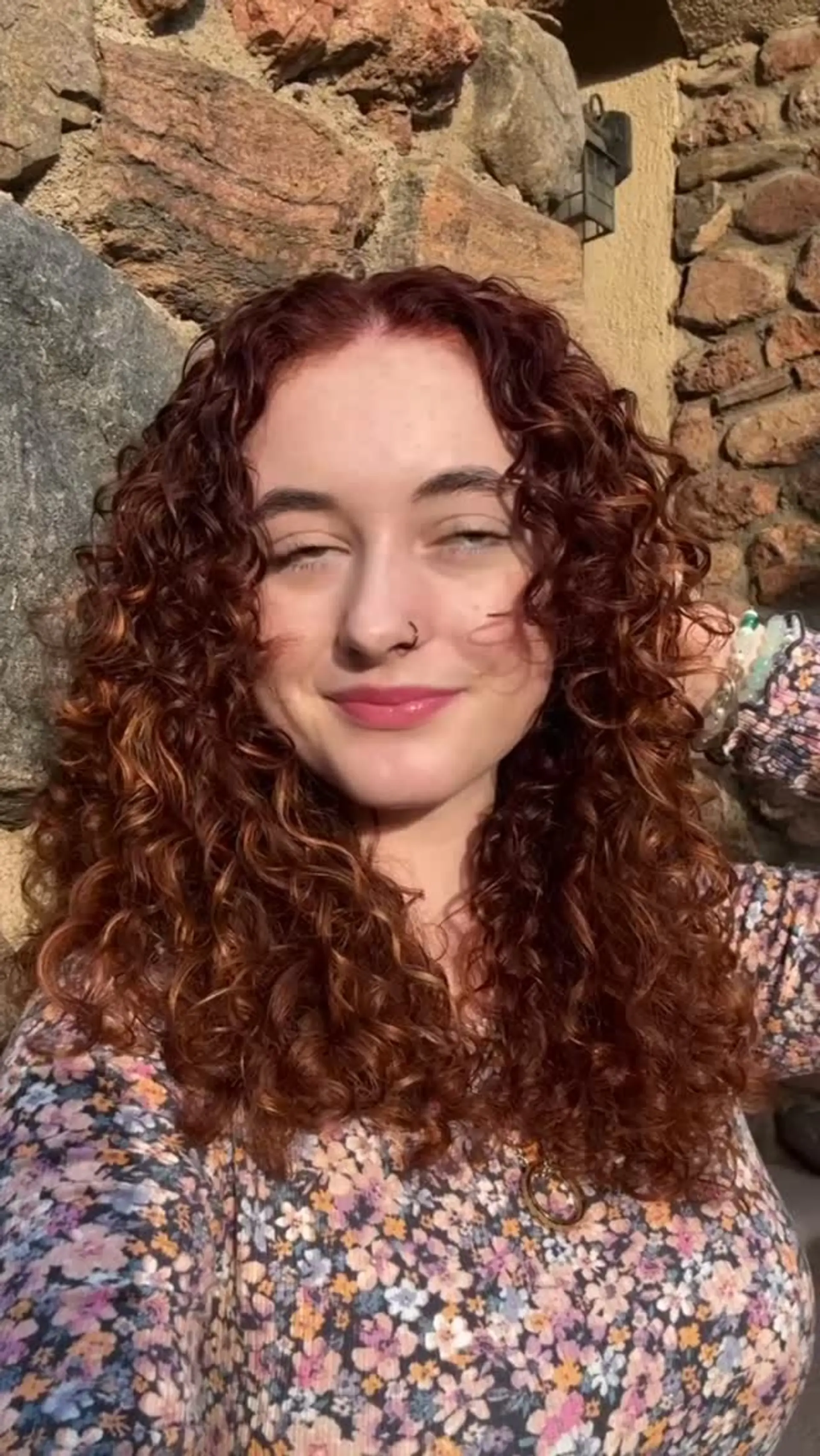 Defined, bouncy medium-length curls colored in a warm, dimensional auburn copper hue. 1