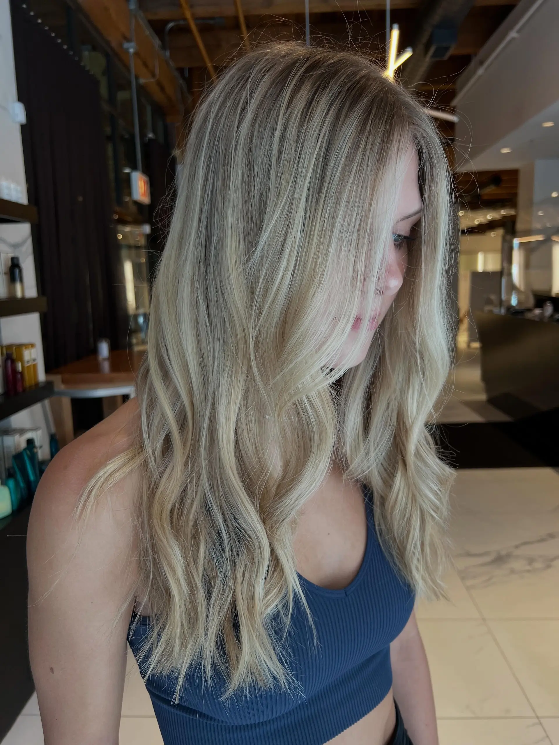 Long dimensional blonde hair styled in soft, cascading waves. 1