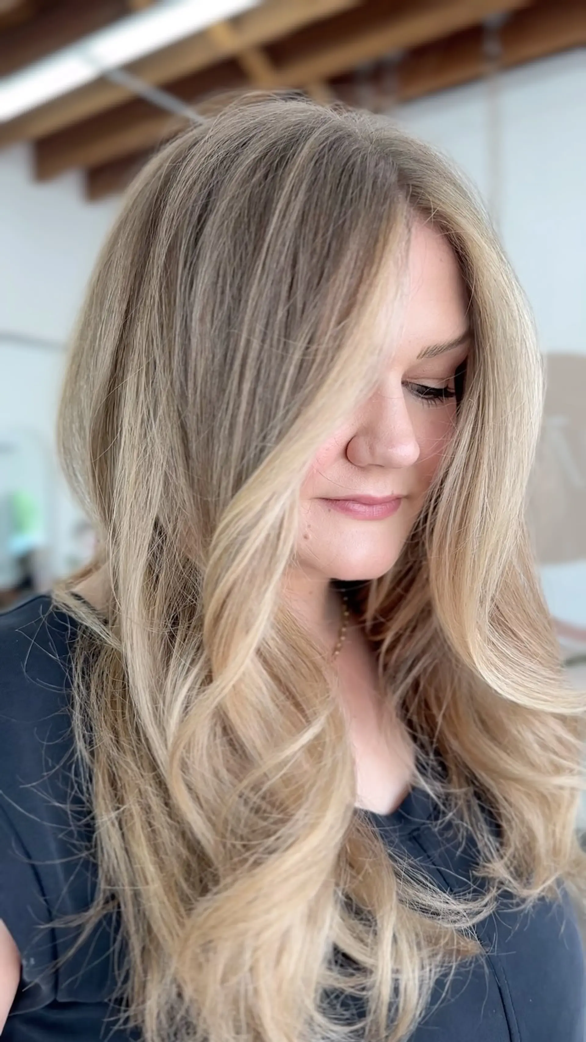 Long multi-tonal blonde hair styled with soft, voluminous curls and face-framing layers. 1