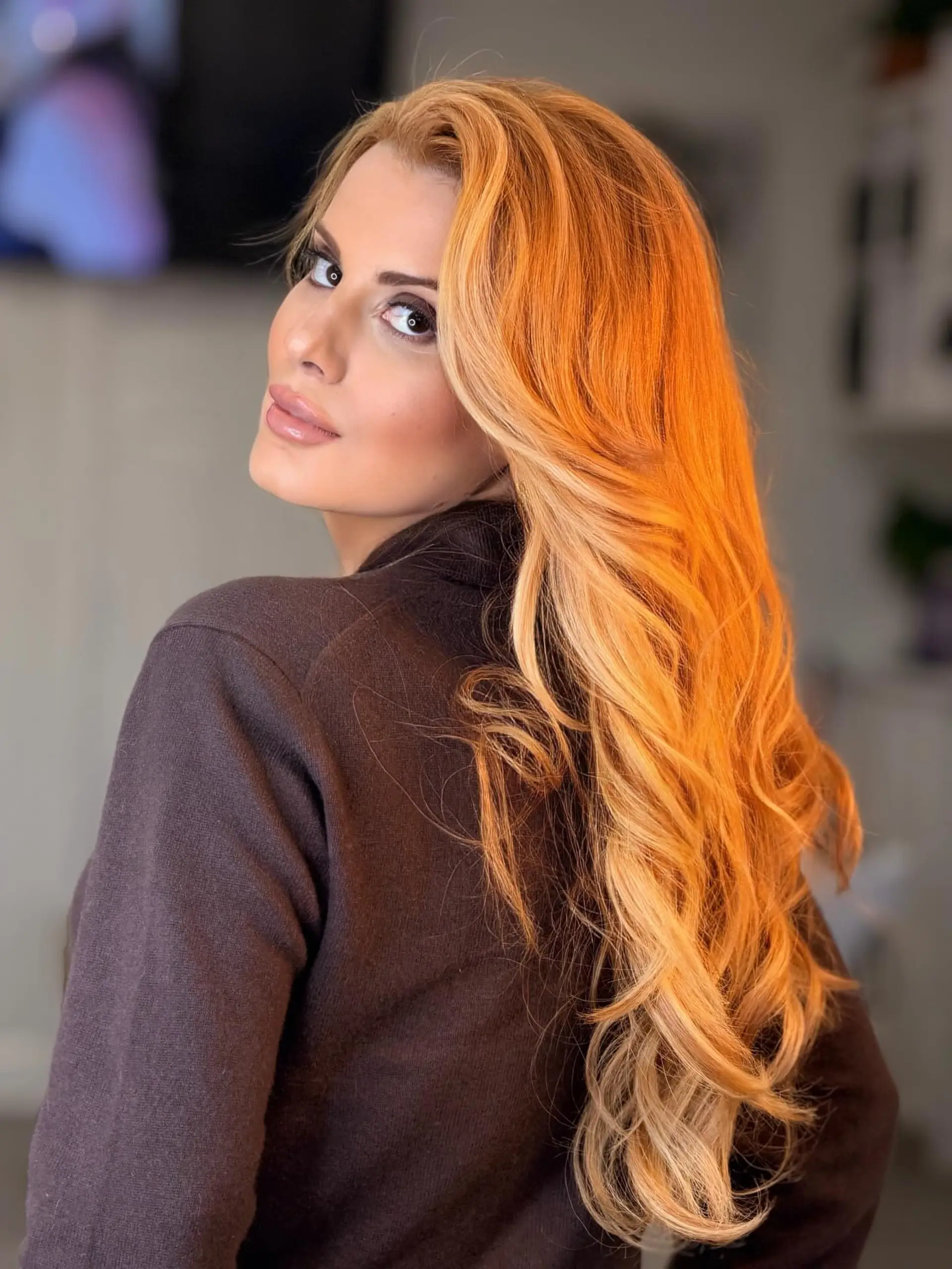 Long, flowing strawberry blonde hair styled into soft, dimensional waves with radiant golden-copper undertones. 1