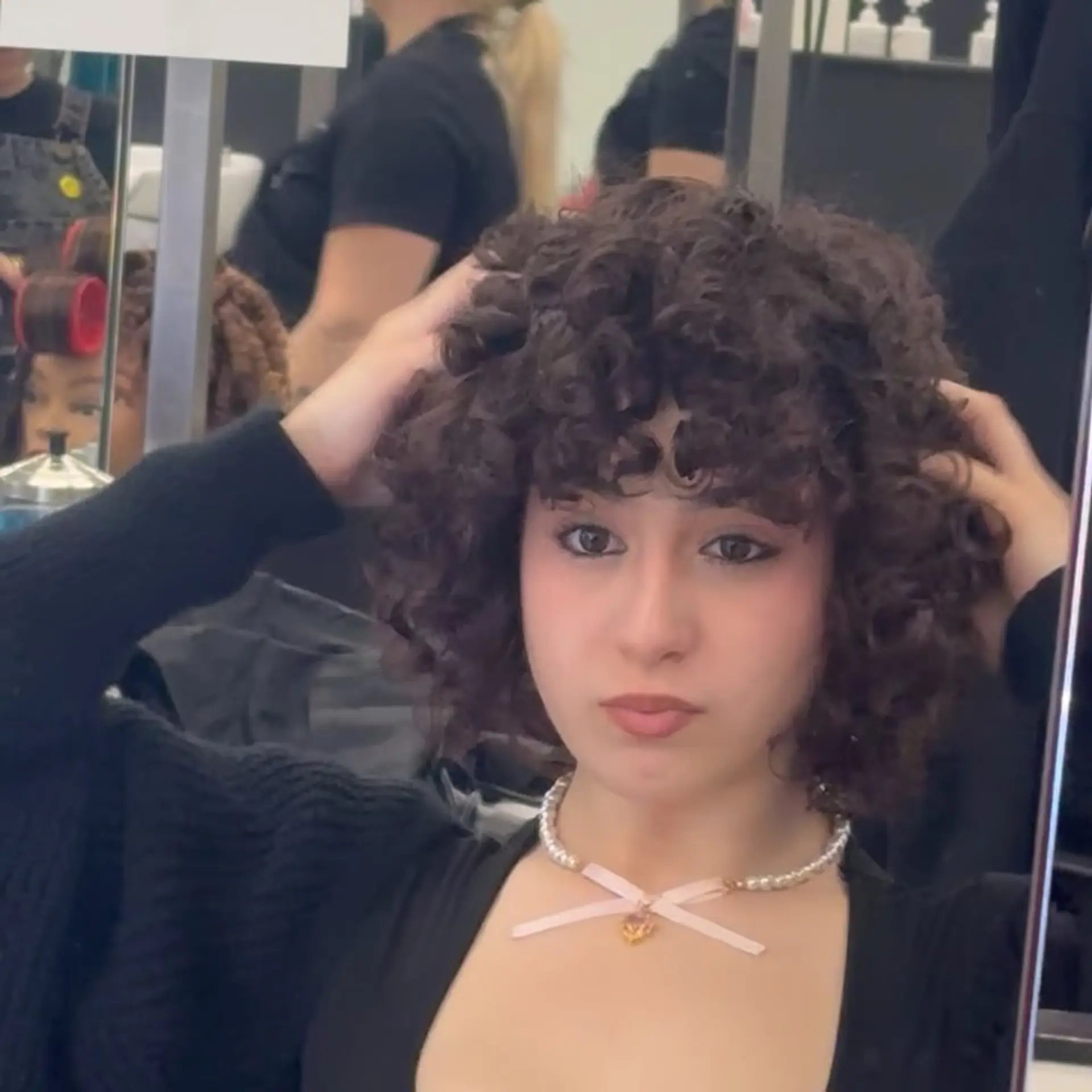 A voluminous short curly bob featuring defined natural ringlets and a curly face-framing fringe. 1