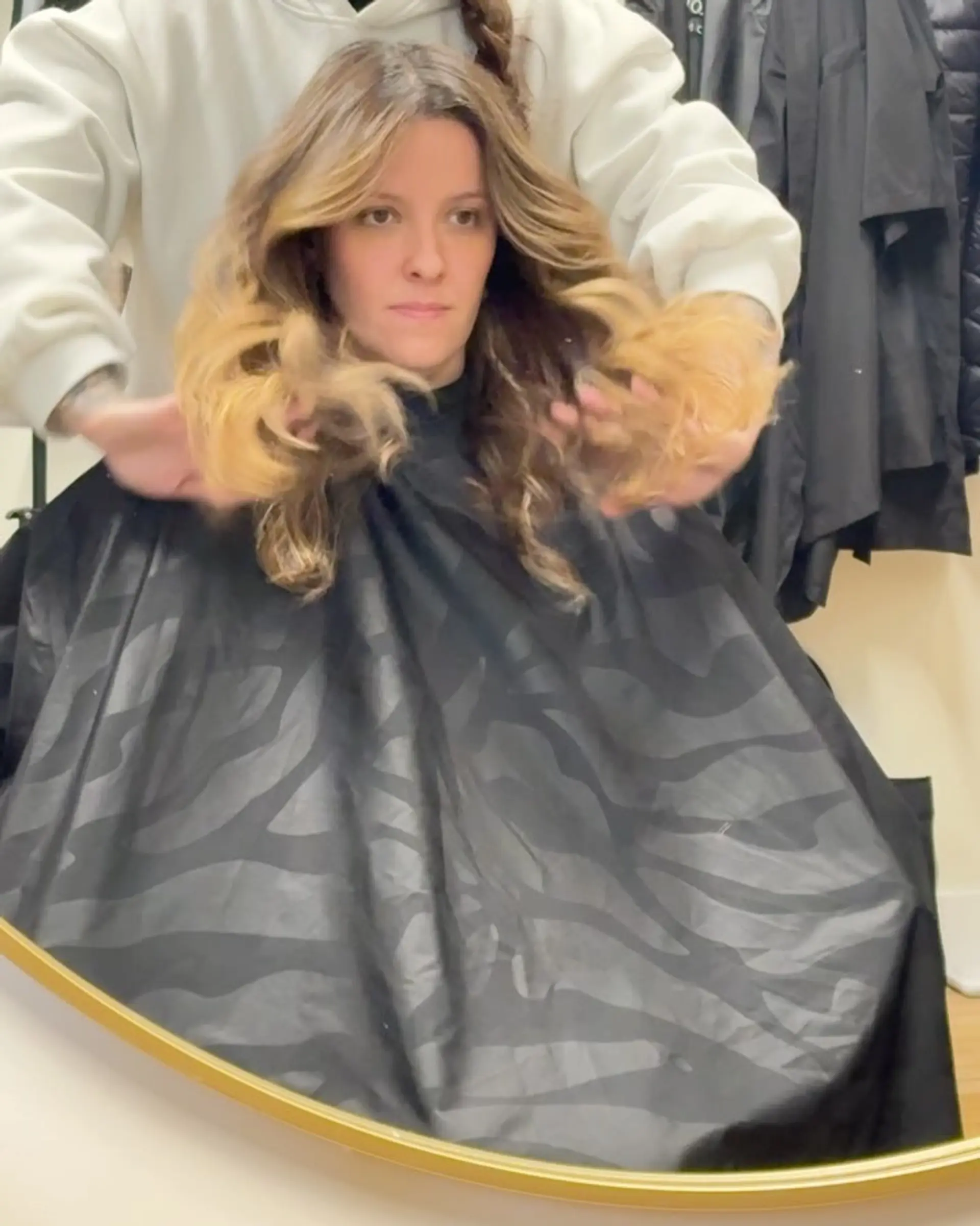 Medium-length layered haircut styled with voluminous, bouncy waves and face-framing pieces. 1