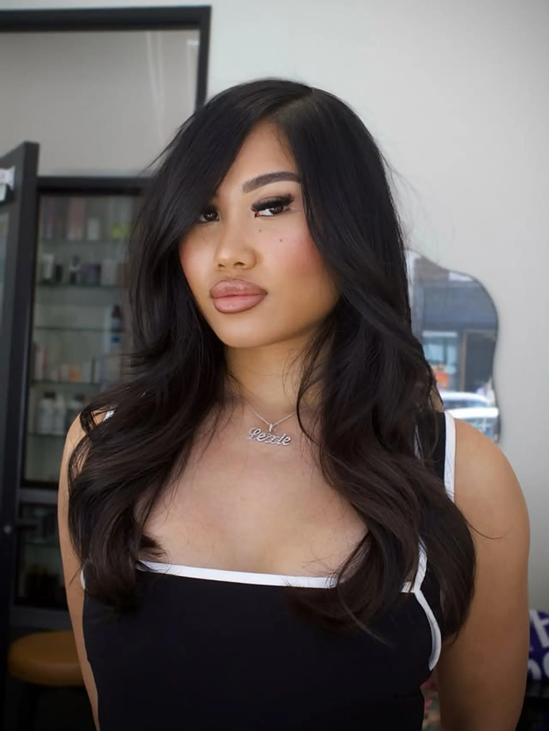 Long hair with layers and curtain bangs styled with a blowout. 1