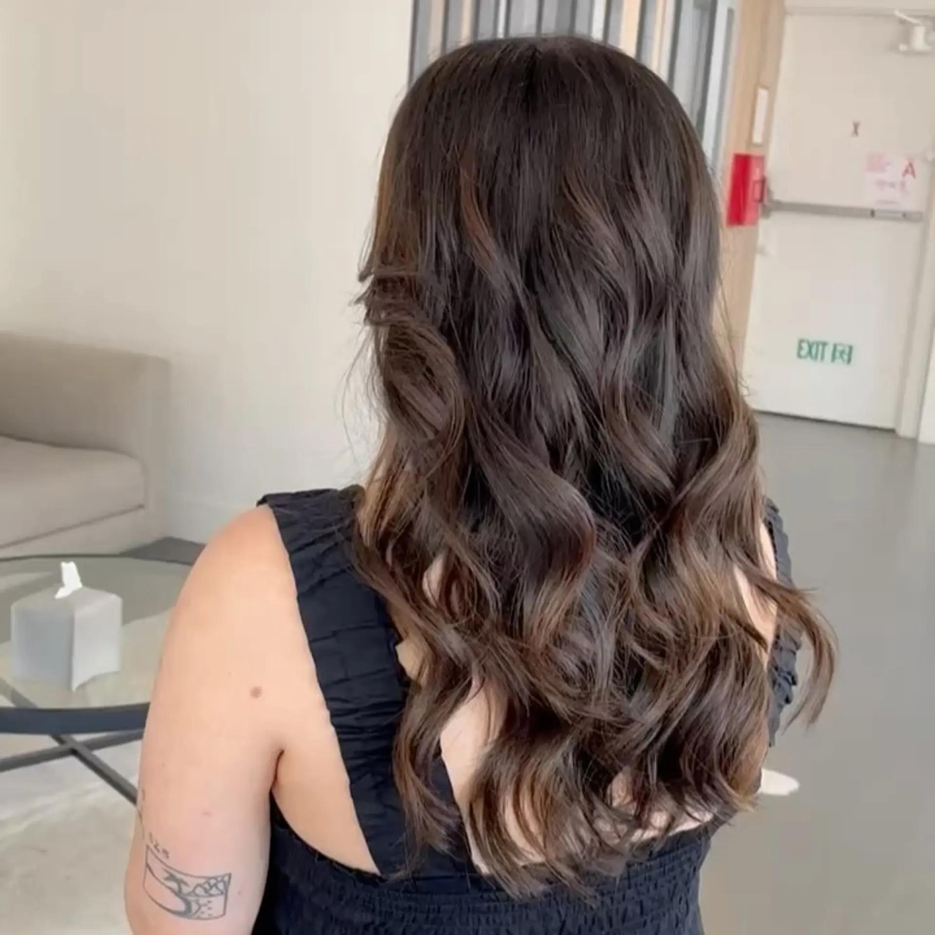 Long chocolate brown hair cut in soft layers and styled with glossy, flowing waves. 1
