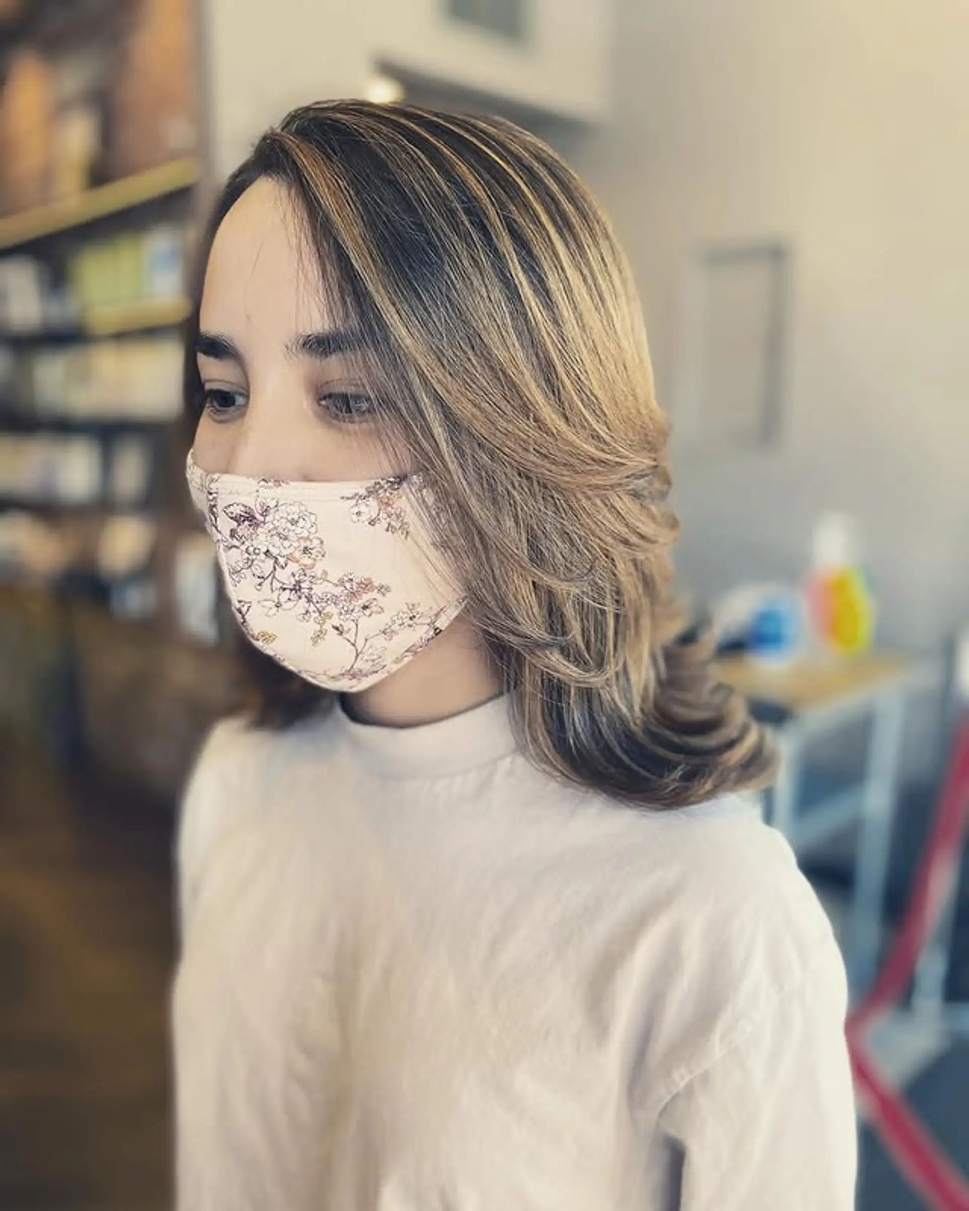 A medium-length layered hairstyle with a soft blowout, creating waves and movement. 1