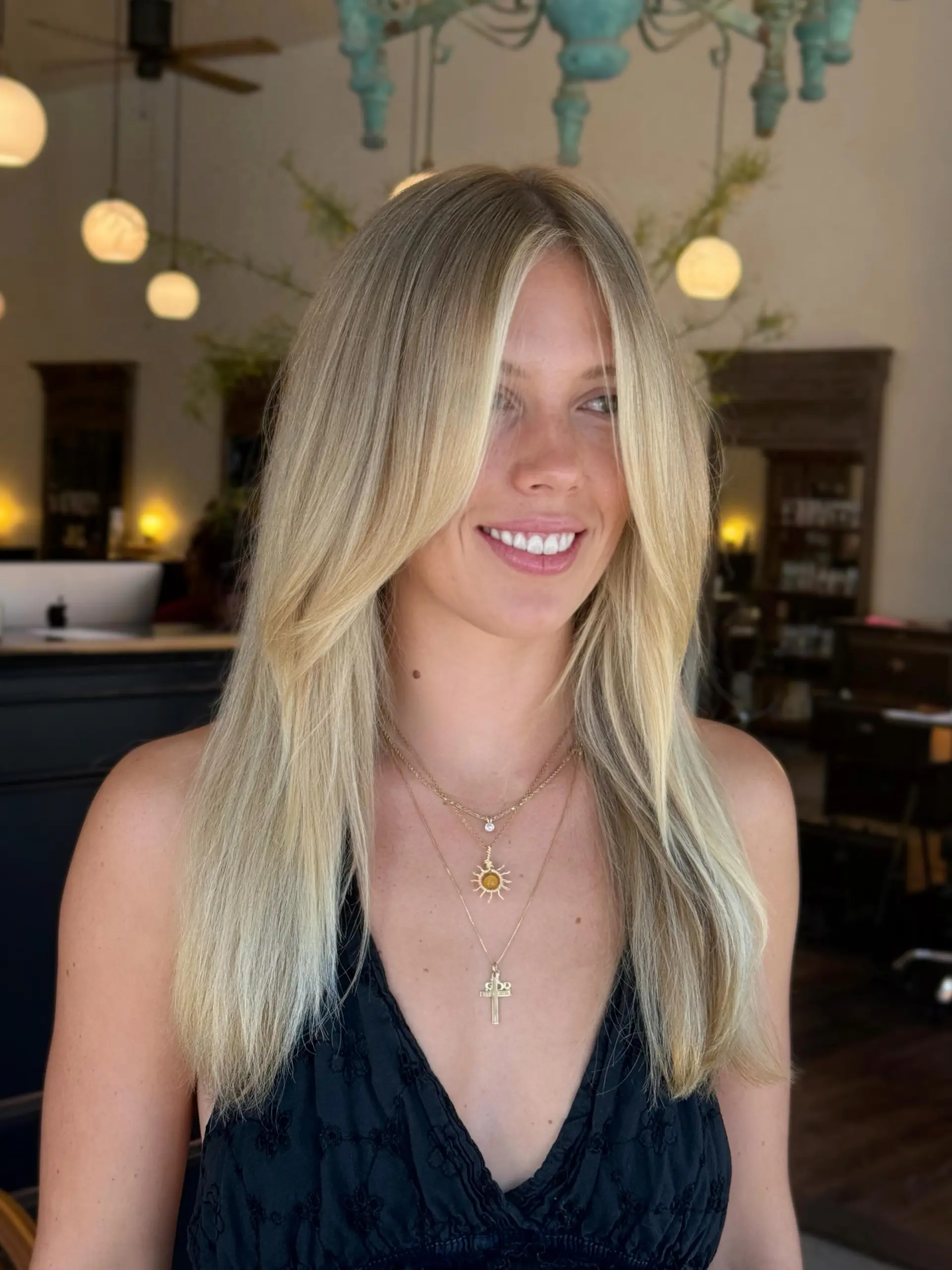 Bright, sun-kissed blonde hair styled smooth with soft face-framing curtain layers. 1